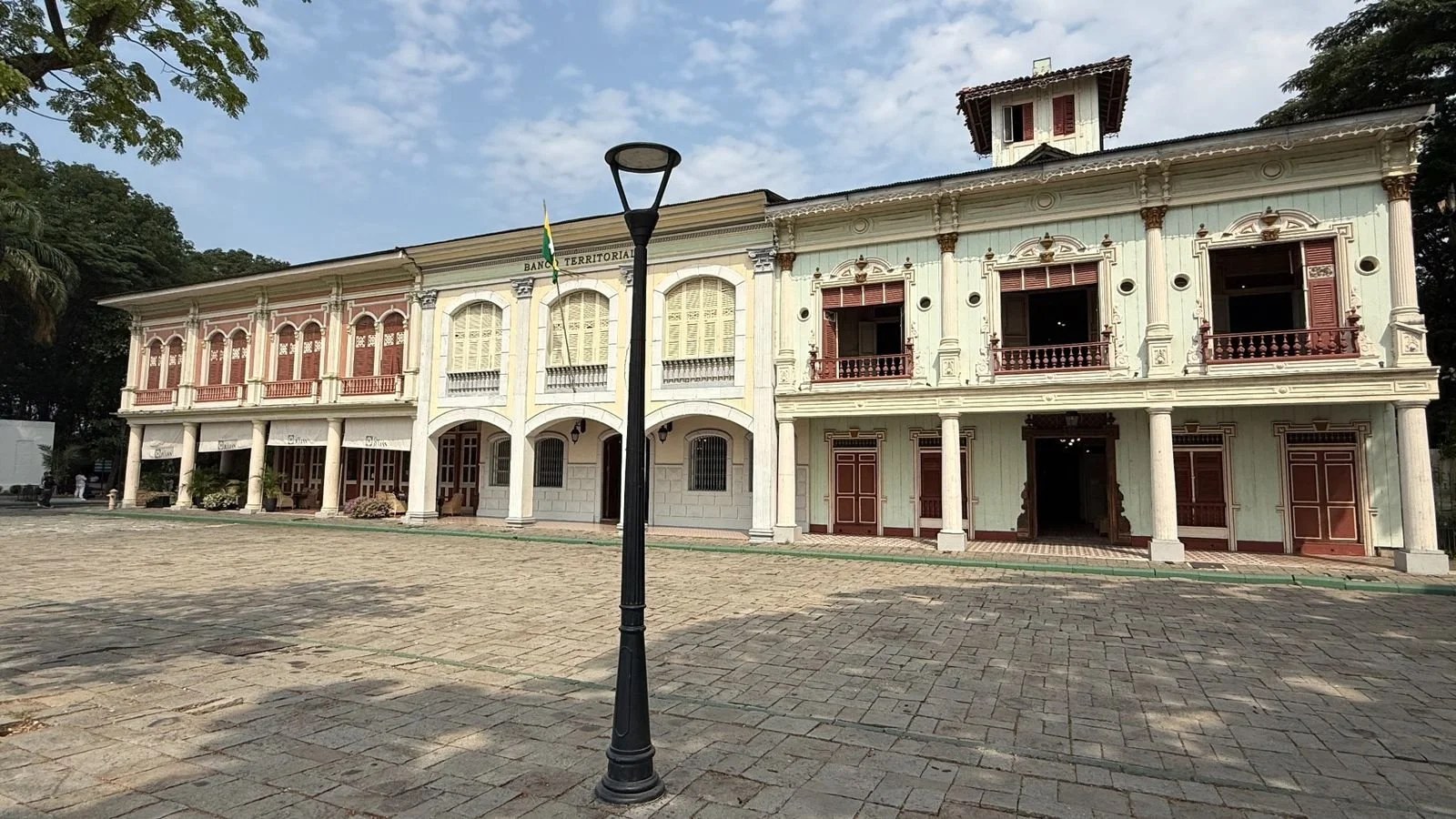 Elegant colonial-style building framed by palm trees and landscaped gardens in Guayaquil
