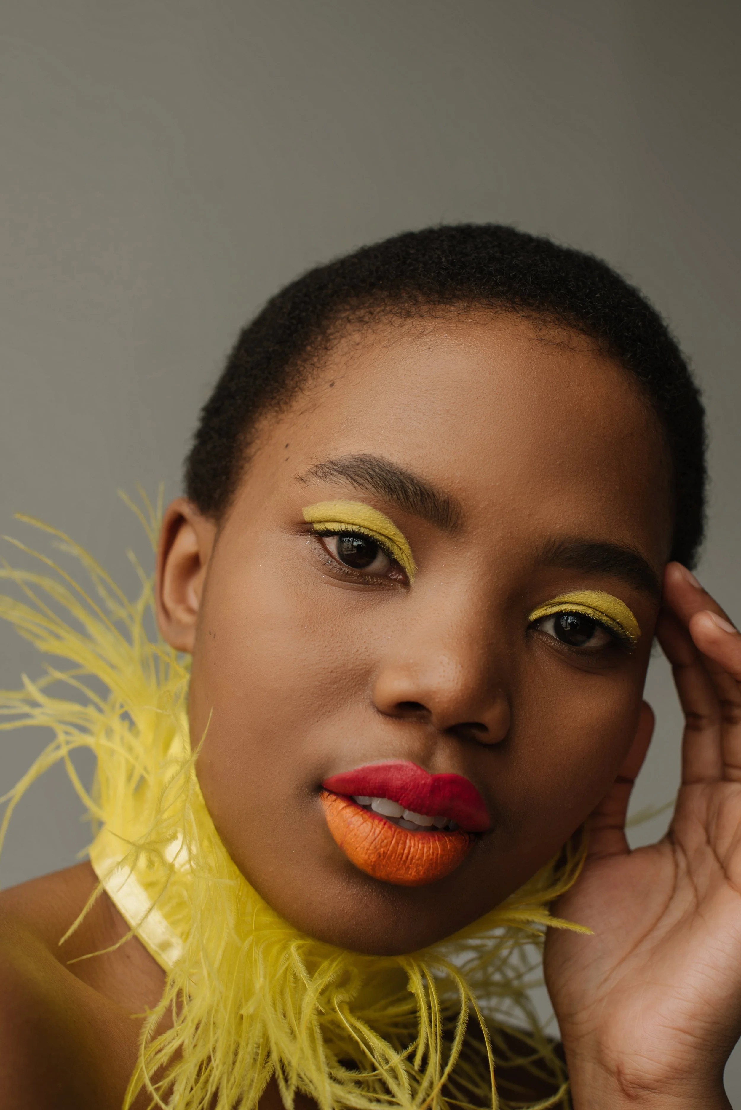 Portrait beauté d'une femme au maquillage coloré et portant des plumes