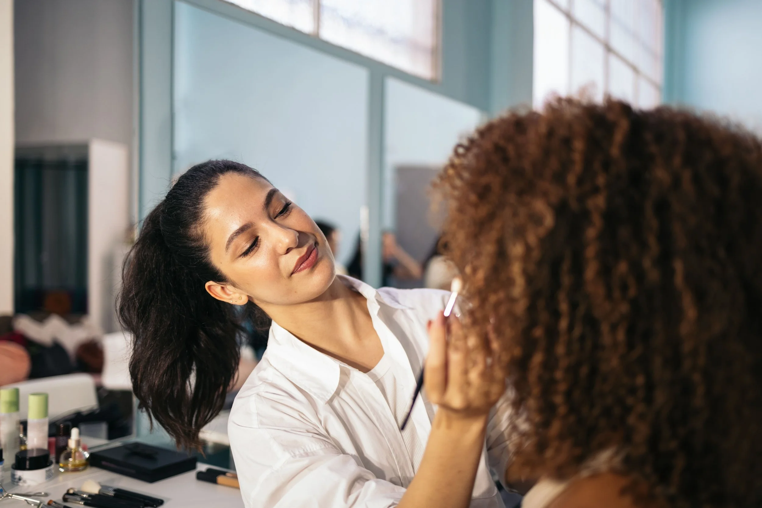 Maquilleuse appliquant du maquillage sur une top model