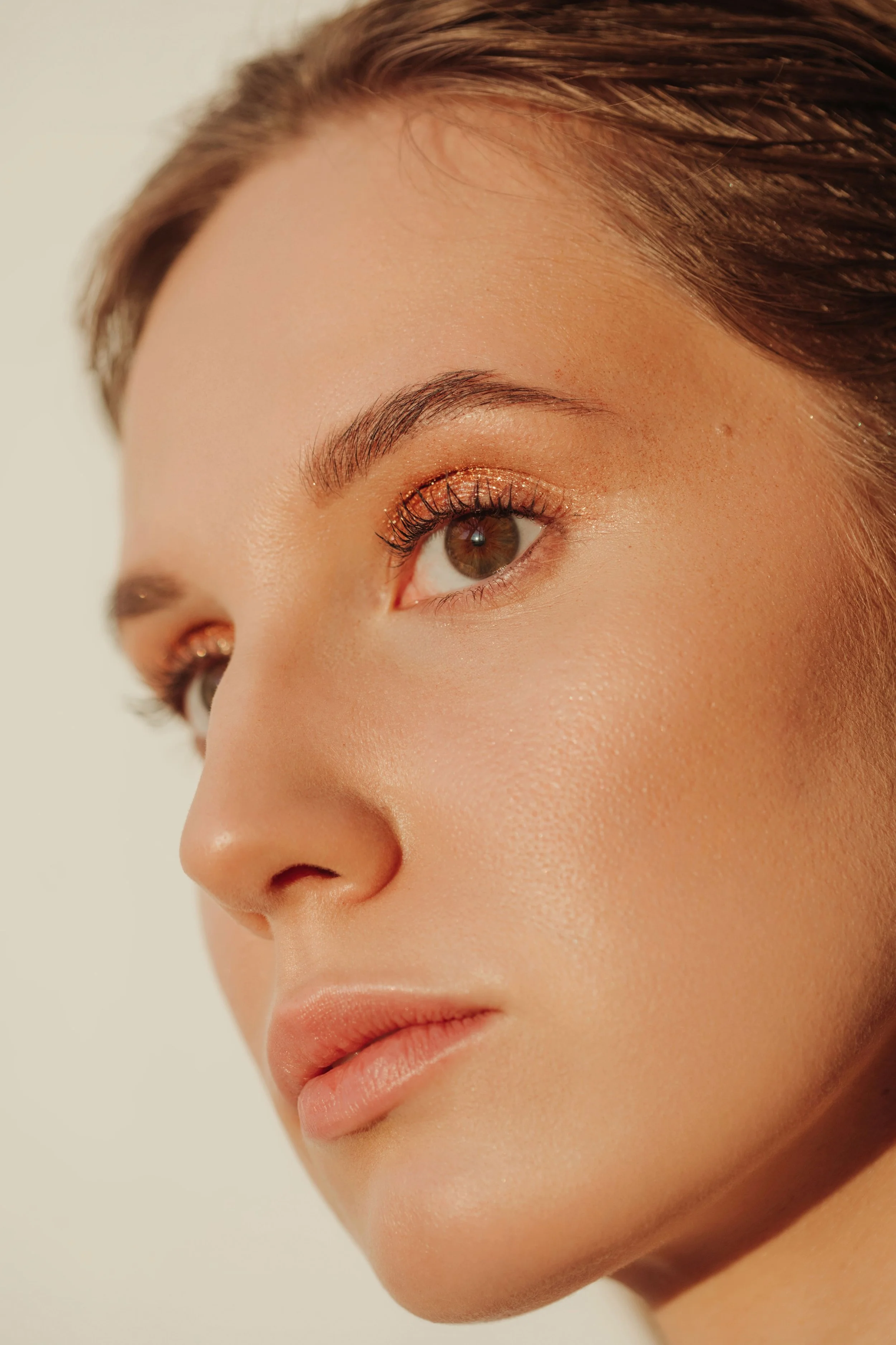 Gros plan beauté d'une jeune femme avec une peau sans imperfection et un maquillage élégant, regardant au loin