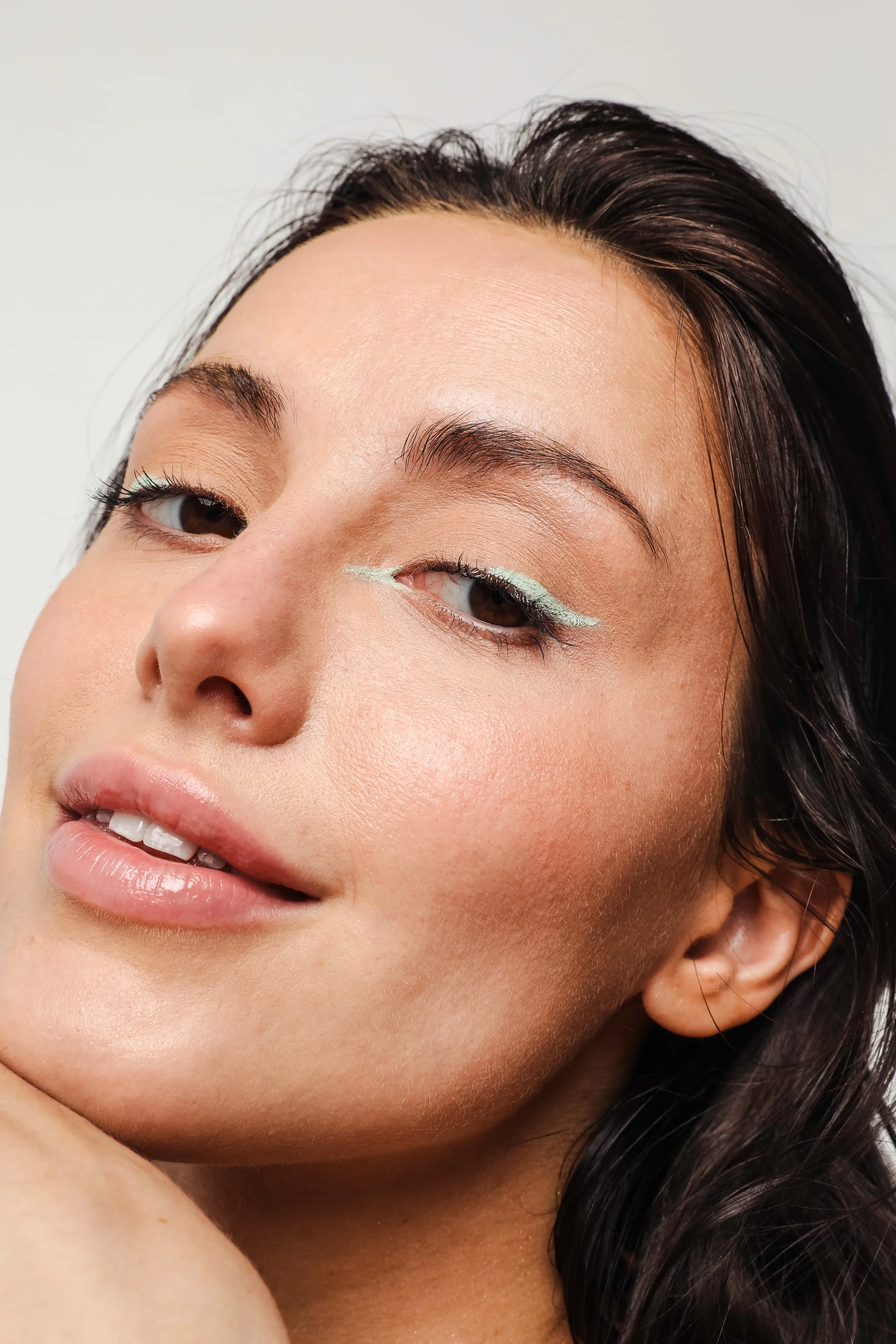 Jeune femme souriante portant de l'eye-liner vert