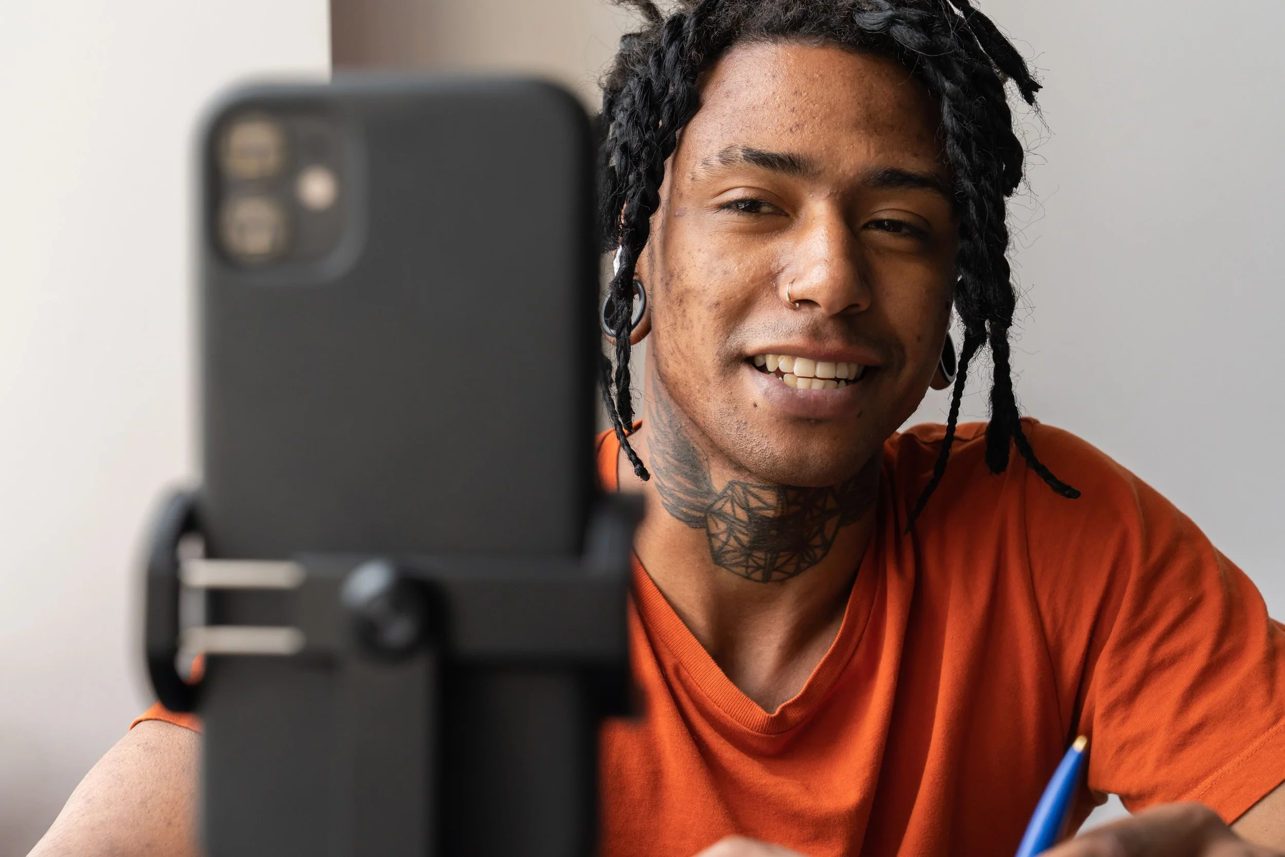 Homem jovem e sorridente faz streaming ao vivo no celular