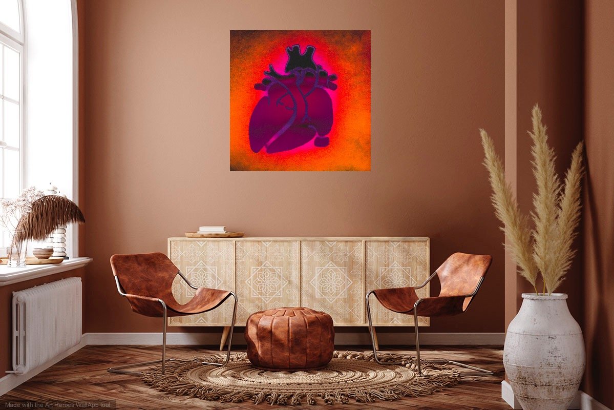 A sitting room with the photo of Beating Heart at Sunrise of a stencil of an anatomical heart filled with ethereal deep pink that fades to black on top, glowing in teds and orange like a sunrise.