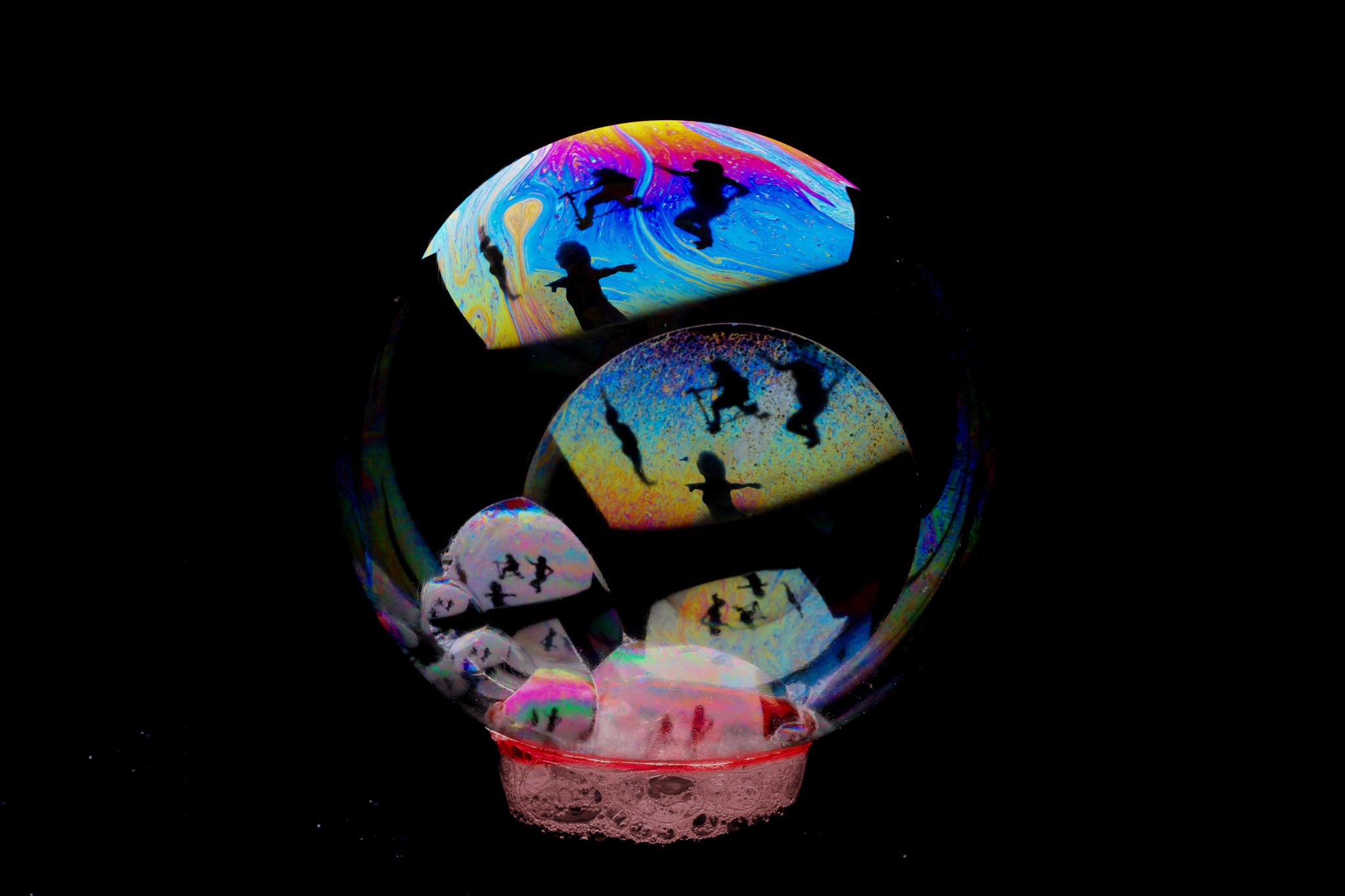 Four silhouettes of the artist on a bubble. The four bodies are echoed again and again in layers of the bubble and cropped differently in each reflection. (Copy) (Copy)
