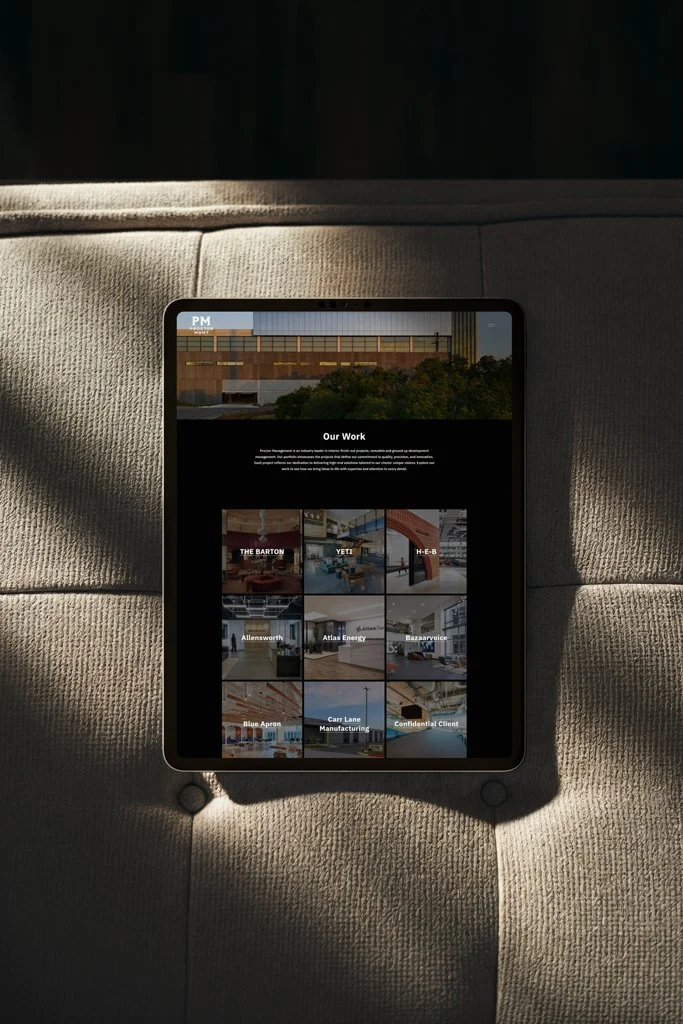 A tablet displaying a portfolio website titled 'Our Work' with images of various architectural and interior design projects, resting on a beige upholstered surface.