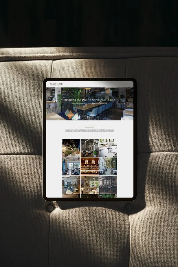 A tablet displaying a website with the headline "Bringing the Pacific Northwest Inside," placed on a beige sofa with sunlight casting shadows.