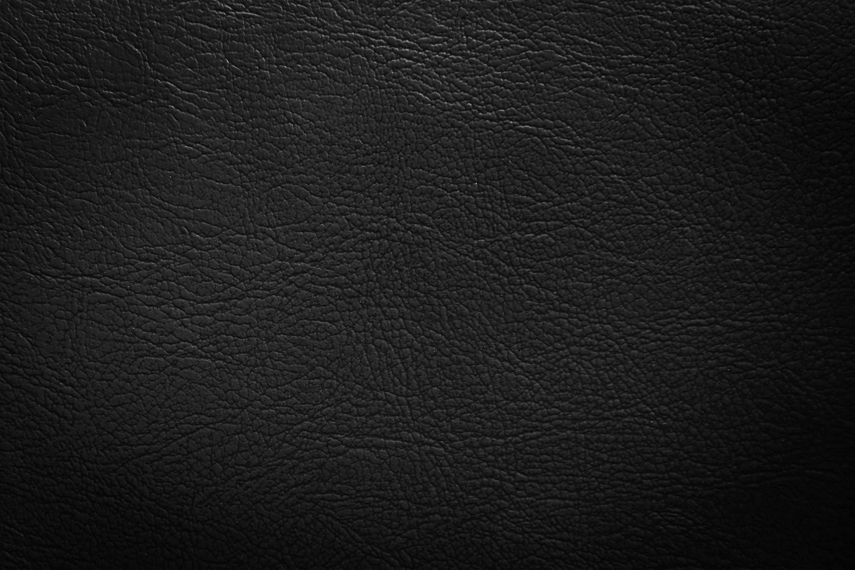 Close-up of black textured leather surface with fine grain patterns.