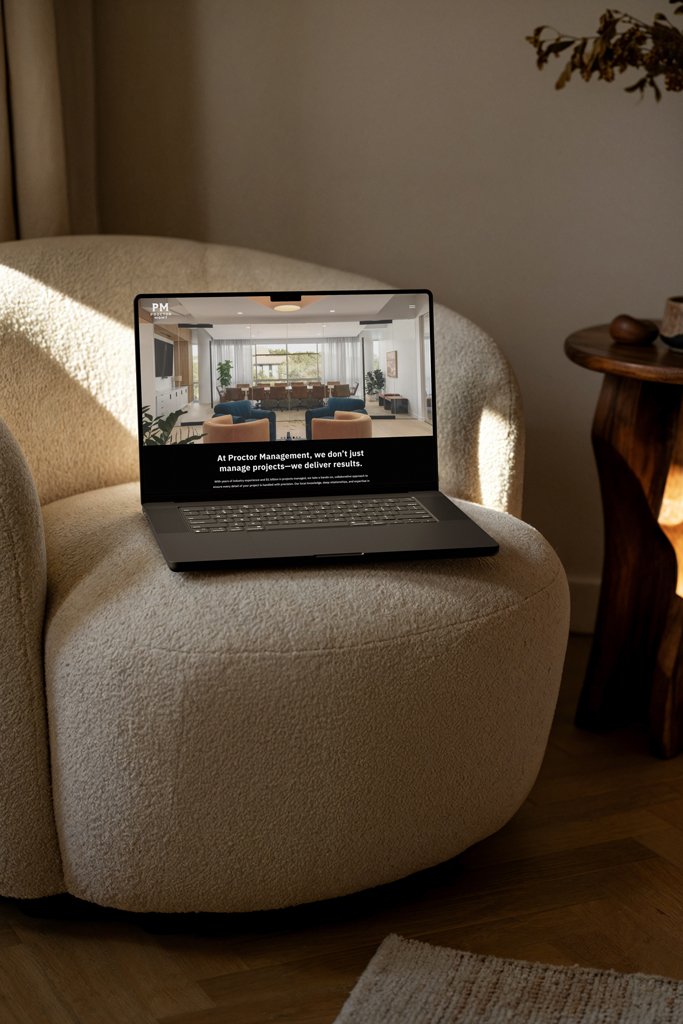 A laptop sitting on a beige armchair with a webpage displayed, showing a living room and text about project management.