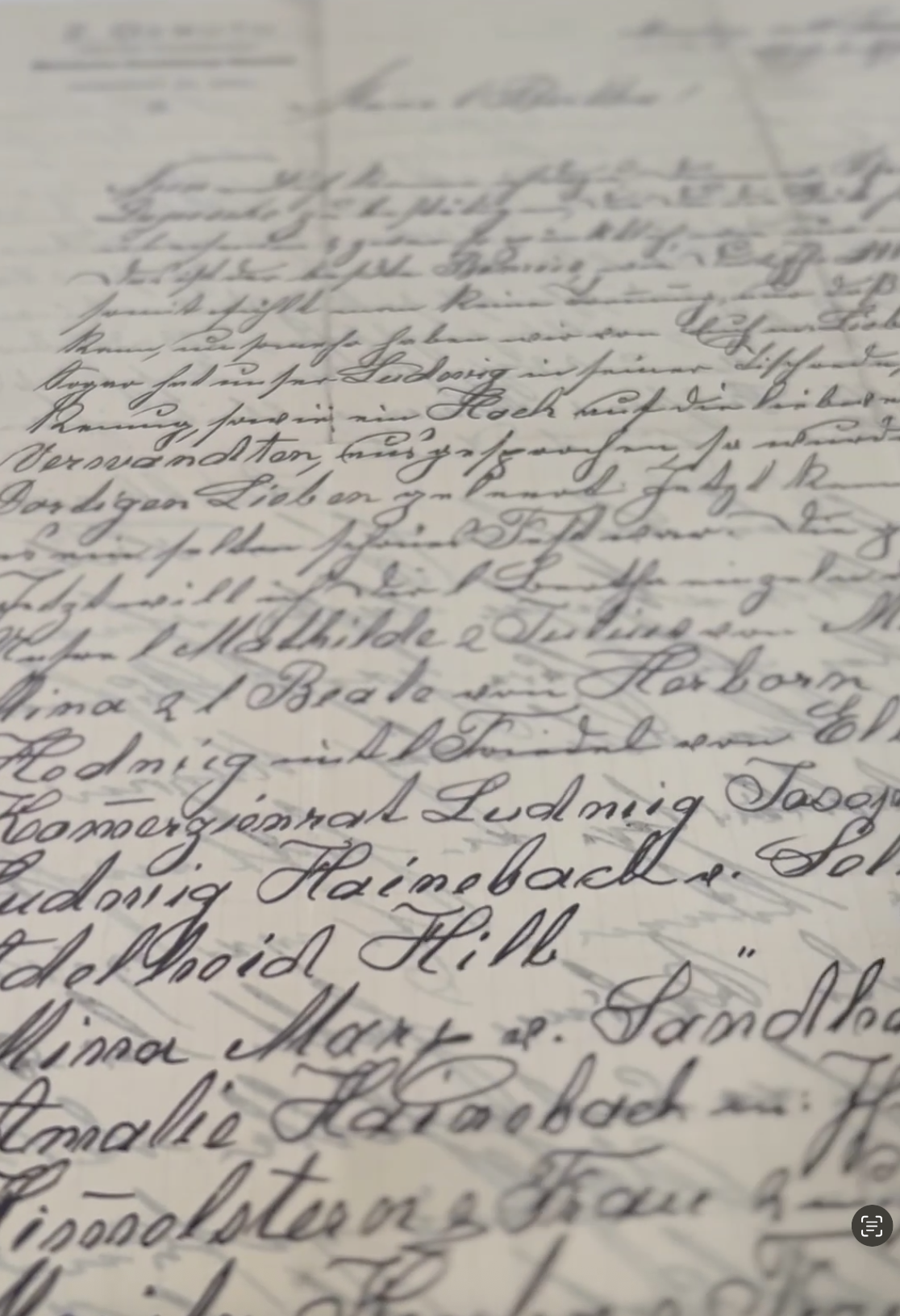Close-up of handwritten cursive letter on paper, difficult to read due to blurriness.