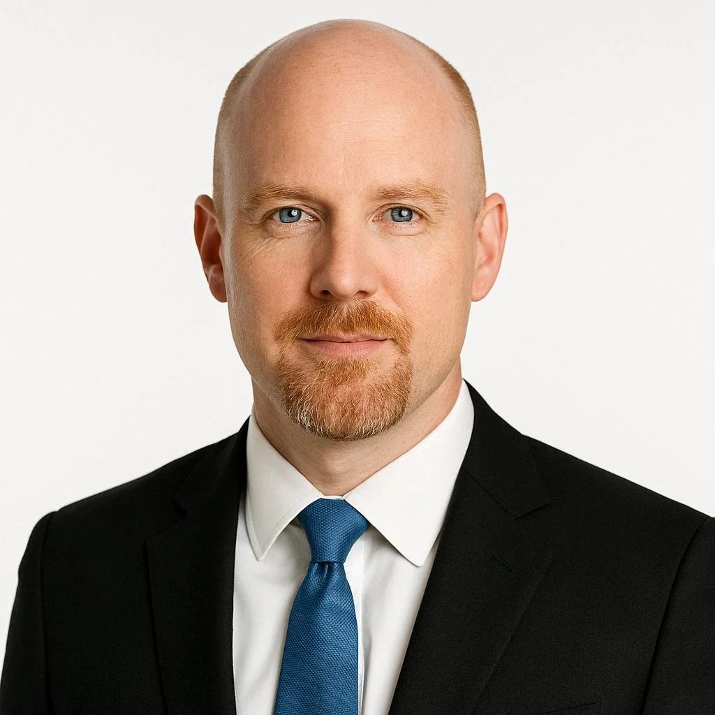 Professional woman with shoulder-length brown hair wearing a red blazer and beige top, against a white background.