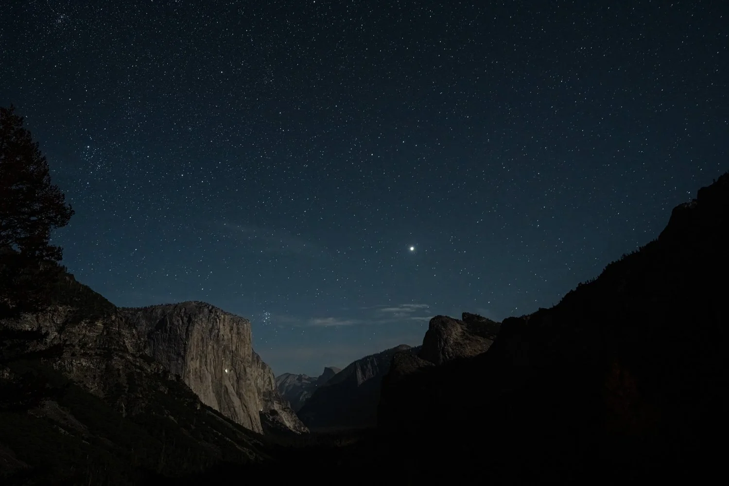 Night sky filled with stars over a mountainous landscape.