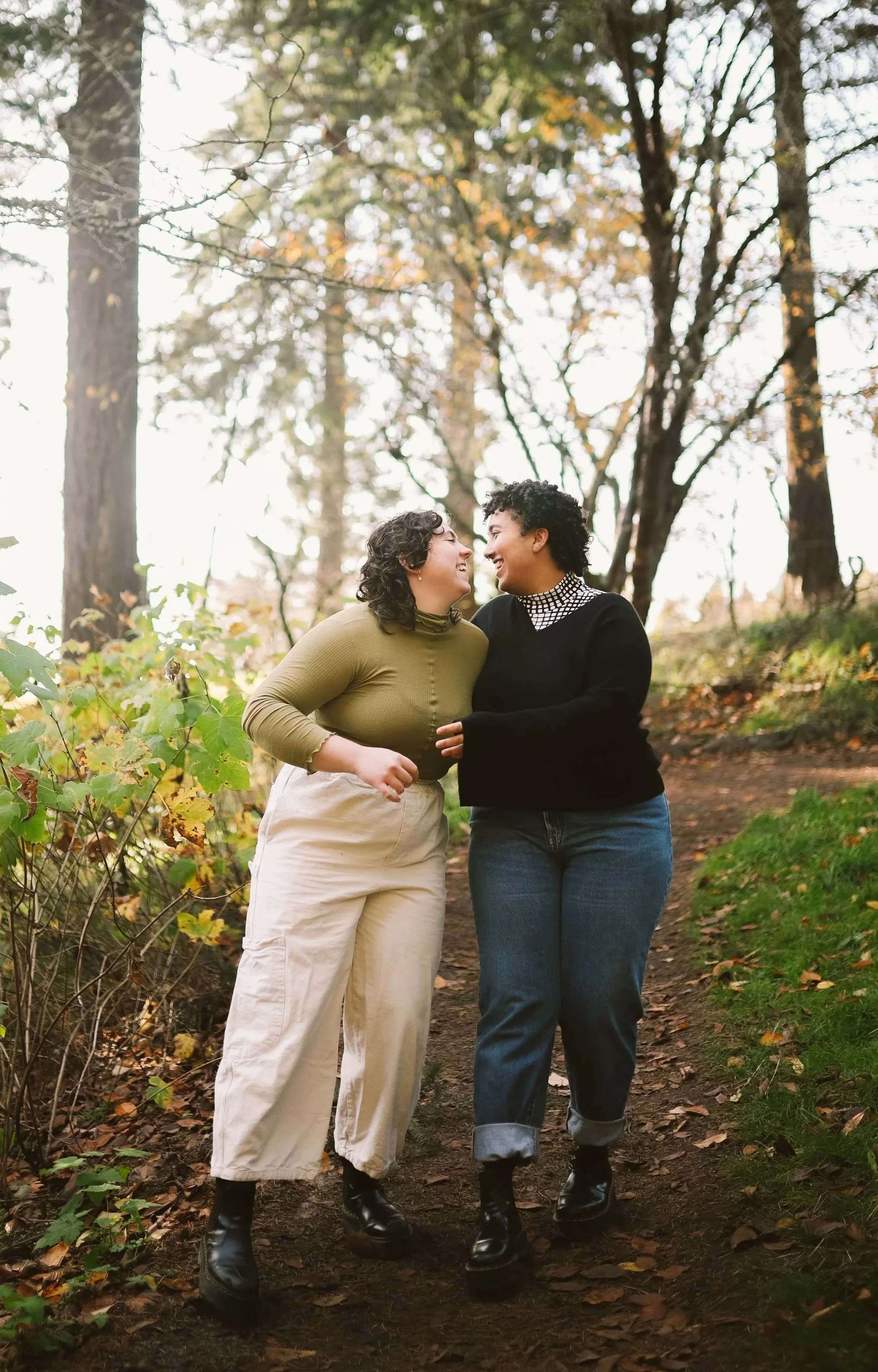 two women walking together on a nature trail smiling at each other at Couples Therapy Massachusetts.