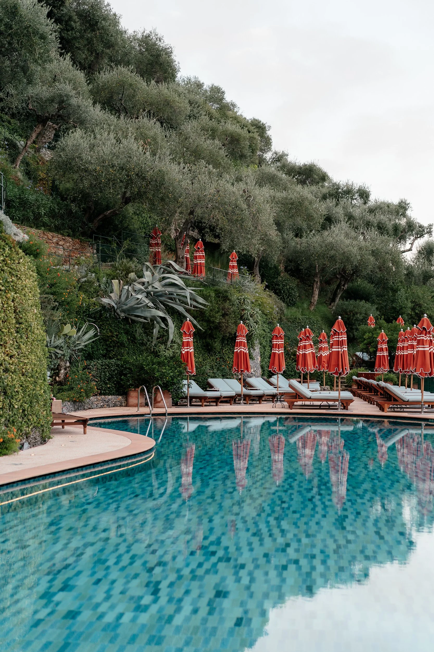 Swimming pool with orange umbrellas overlooking Portofino at a Belmond Splendido Wedding, Portofino Italy. Photos taken by editorial destination wedding photographer Weddings by Emma Olivia. 