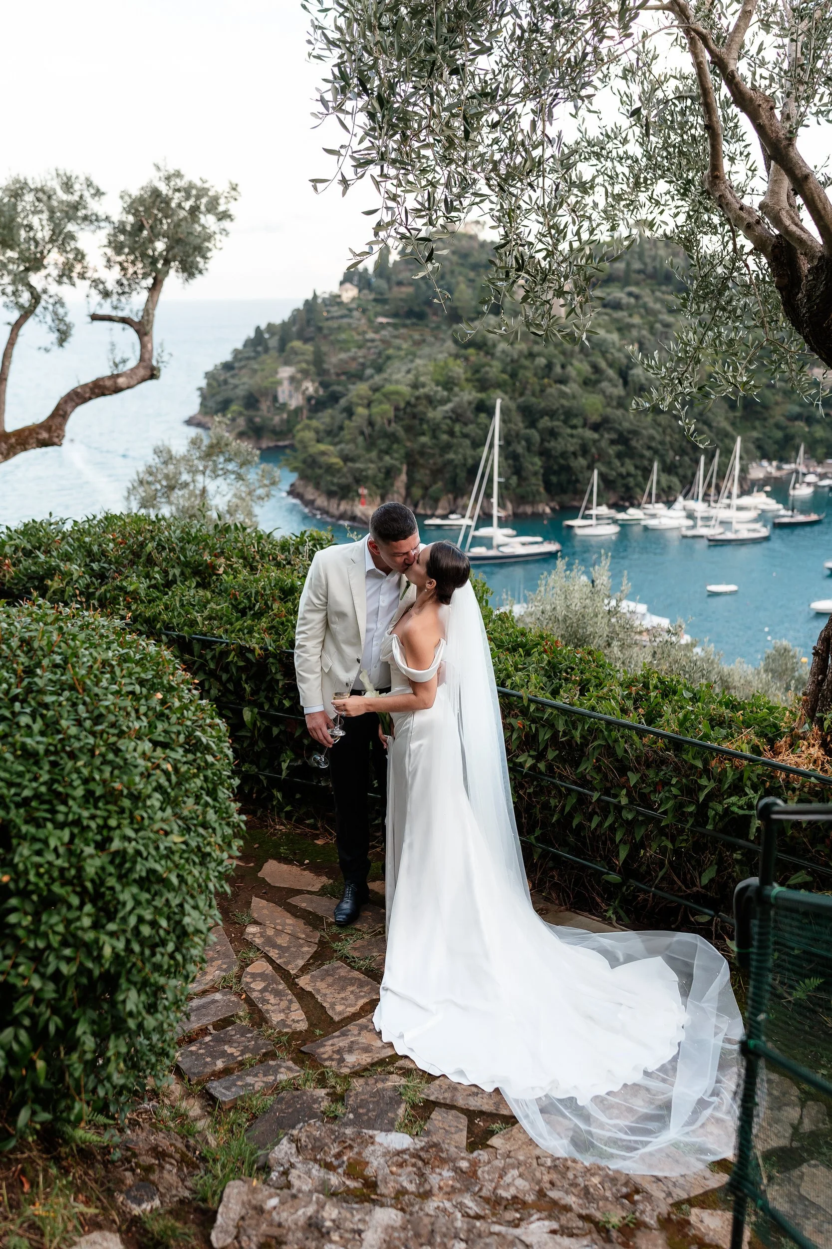 A newlywed couple sharing a kiss outdoors, overlooking Portofino at a Belmond Splendido Wedding, Portofino Italy. Photos taken by editorial destination wedding photographer Weddings by Emma Olivia. 
