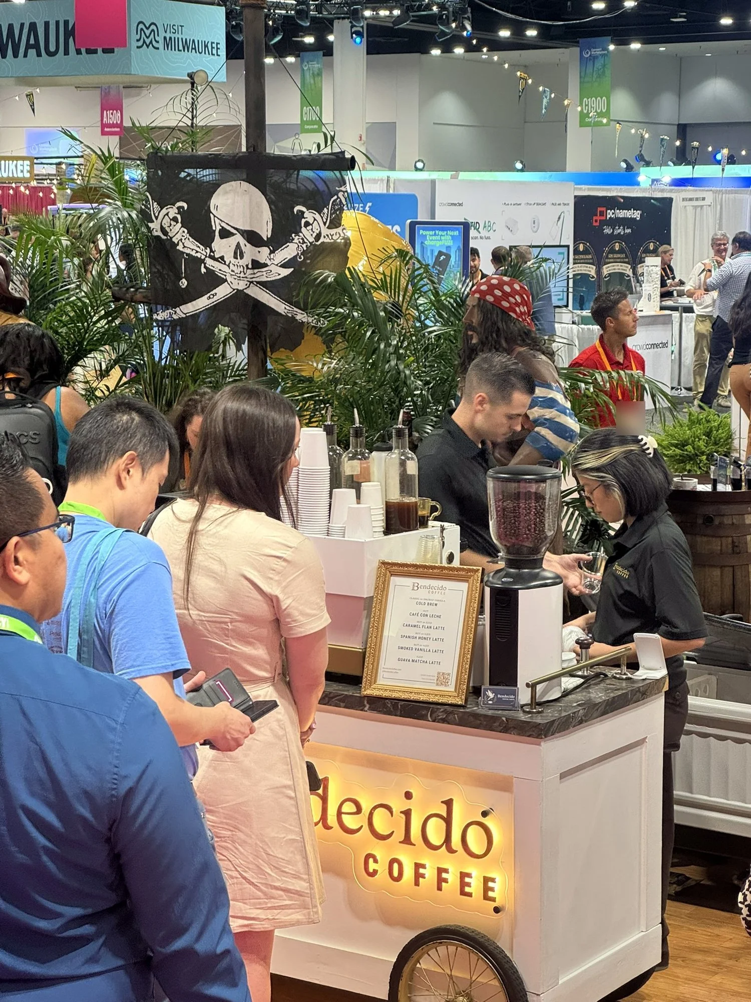 Convention guests lining up at the Bendecido Coffee cart as baristas make drinks on a busy Tampa expo floor