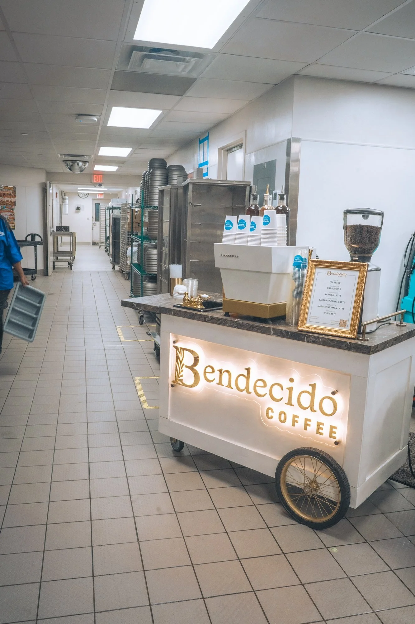 Bendecido Coffee espresso cart with illuminated gold sign set up in a hospital corridor for a staff appreciation coffee service