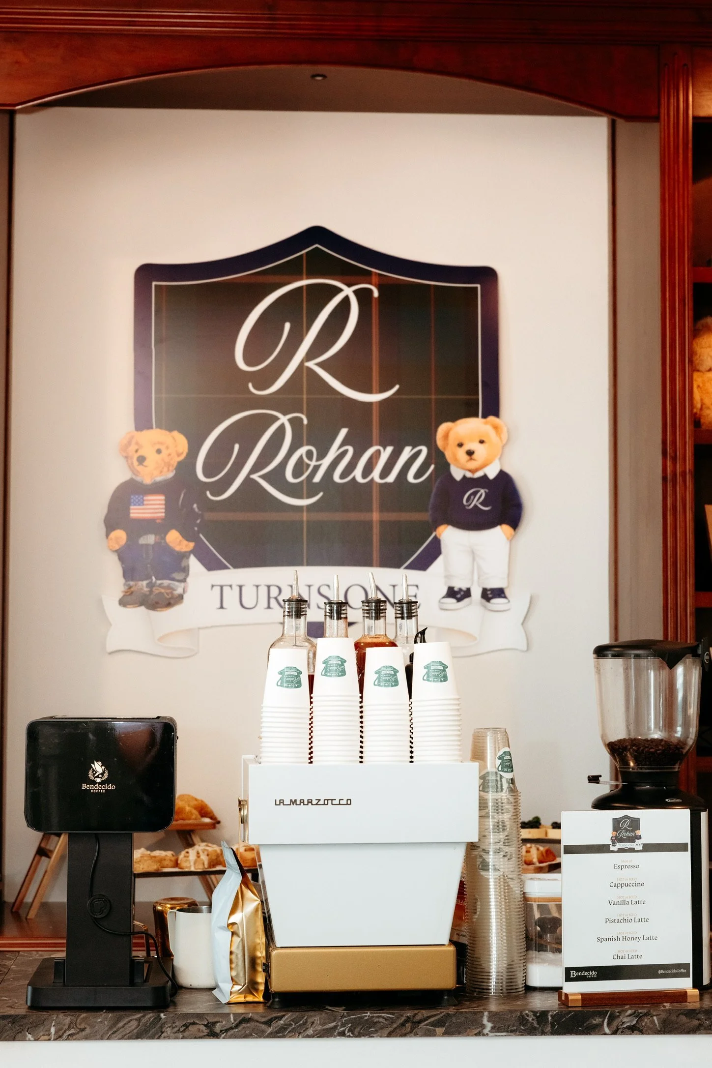 Bendecido Coffee cart set up indoors in front of a decorative wall sign and a television