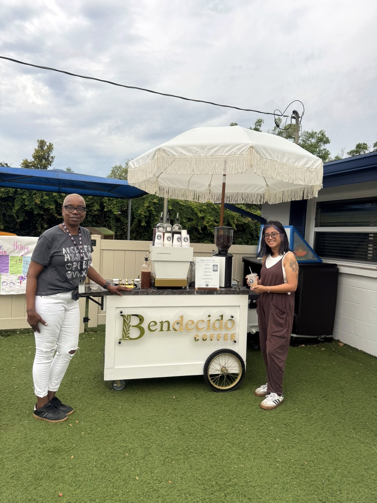 Guests standing with the Bendecido Coffee cart and umbrella at an outdoor lawn party in Tampa Bay