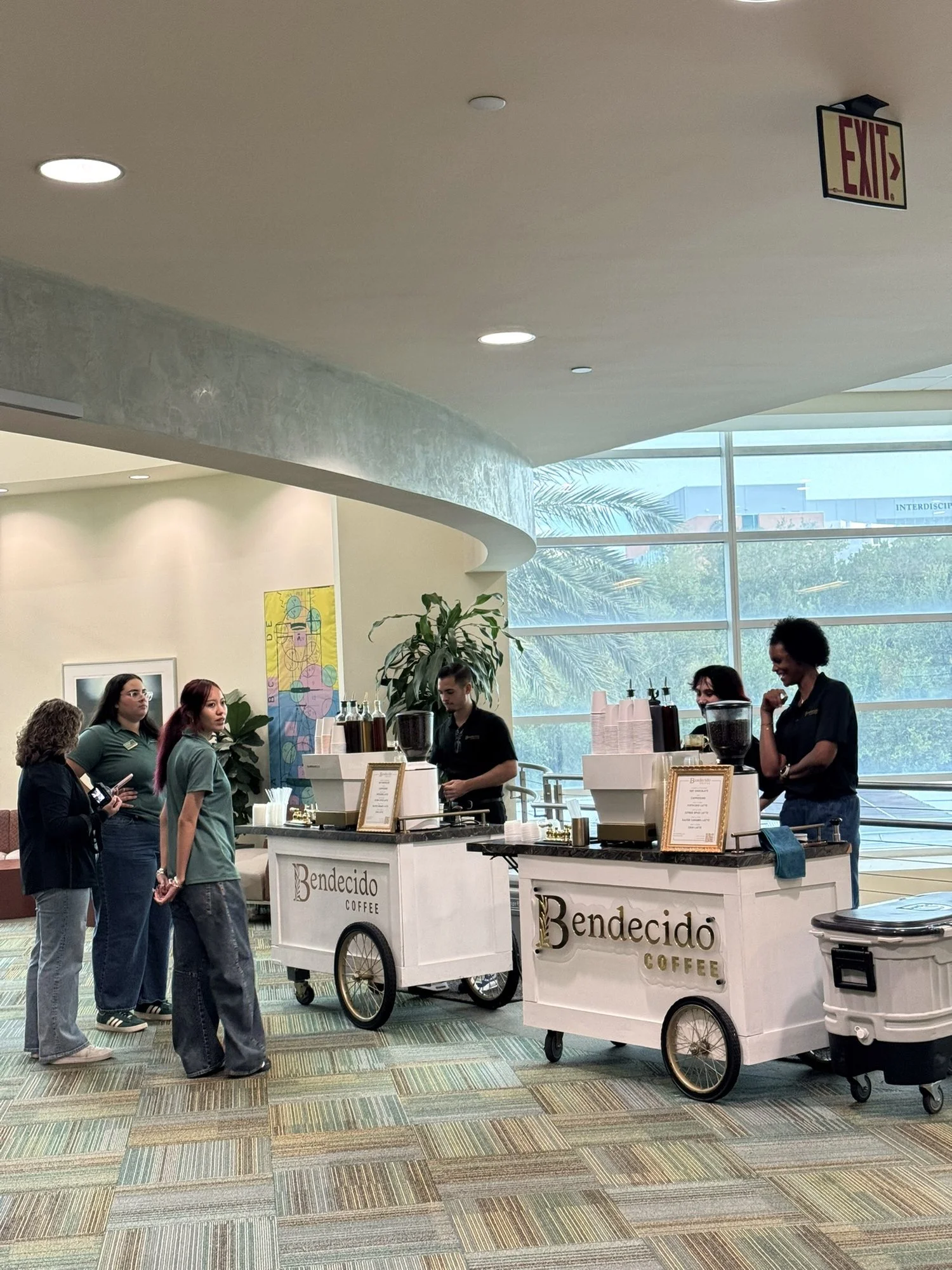 Guests gathering around two Bendecido Coffee carts at a bright Tampa Bay corporate event