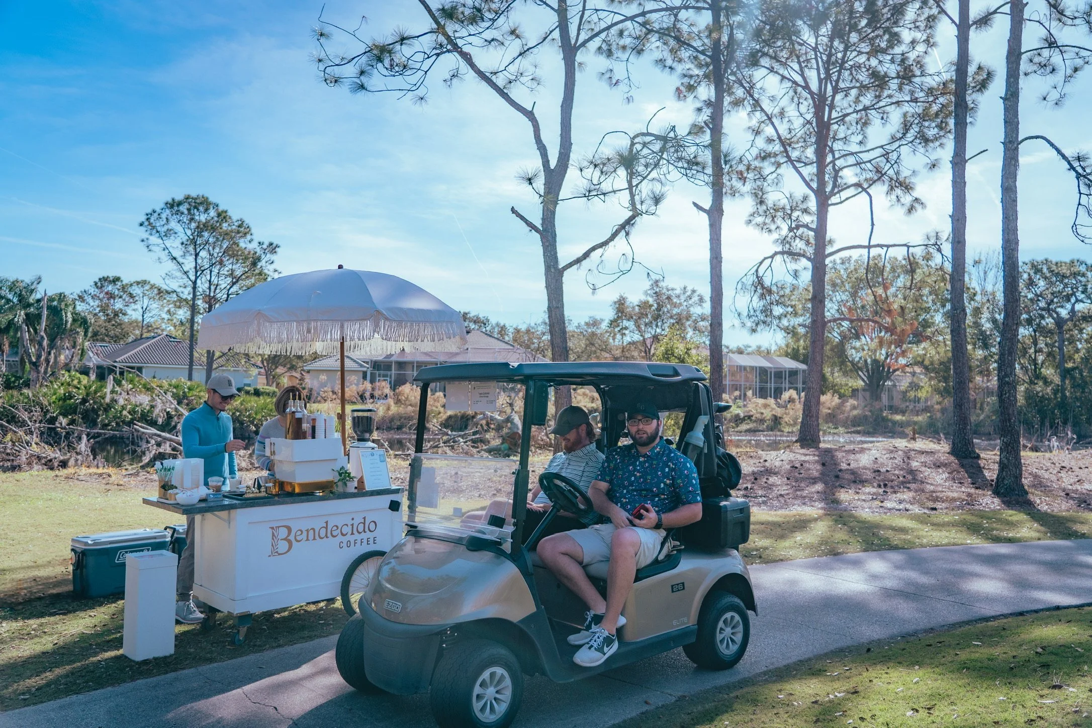 Bendecido Coffee cart on a golf course path beside a golf cart with guests