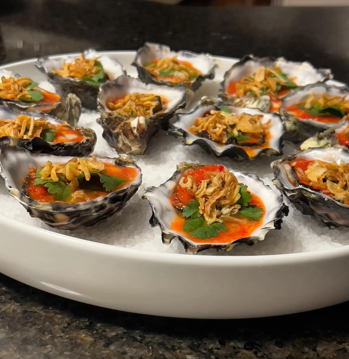 Fresh shucked Oysters with red nahm jim, lime and crisp shallots.