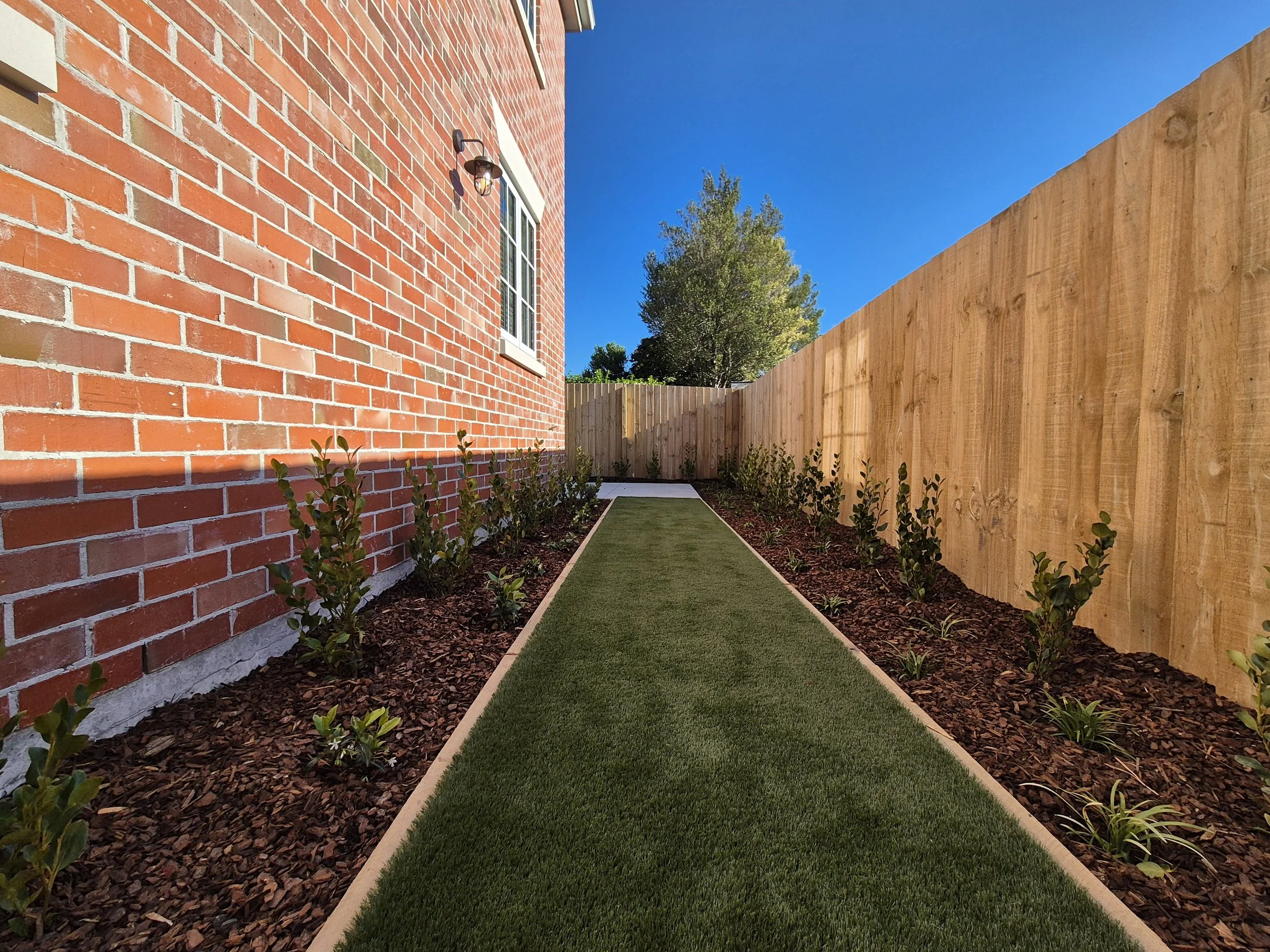 Townhouse landscaping in Christchurch for Brookfield Homes by Outright Property Services, featuring planting and mulching.
