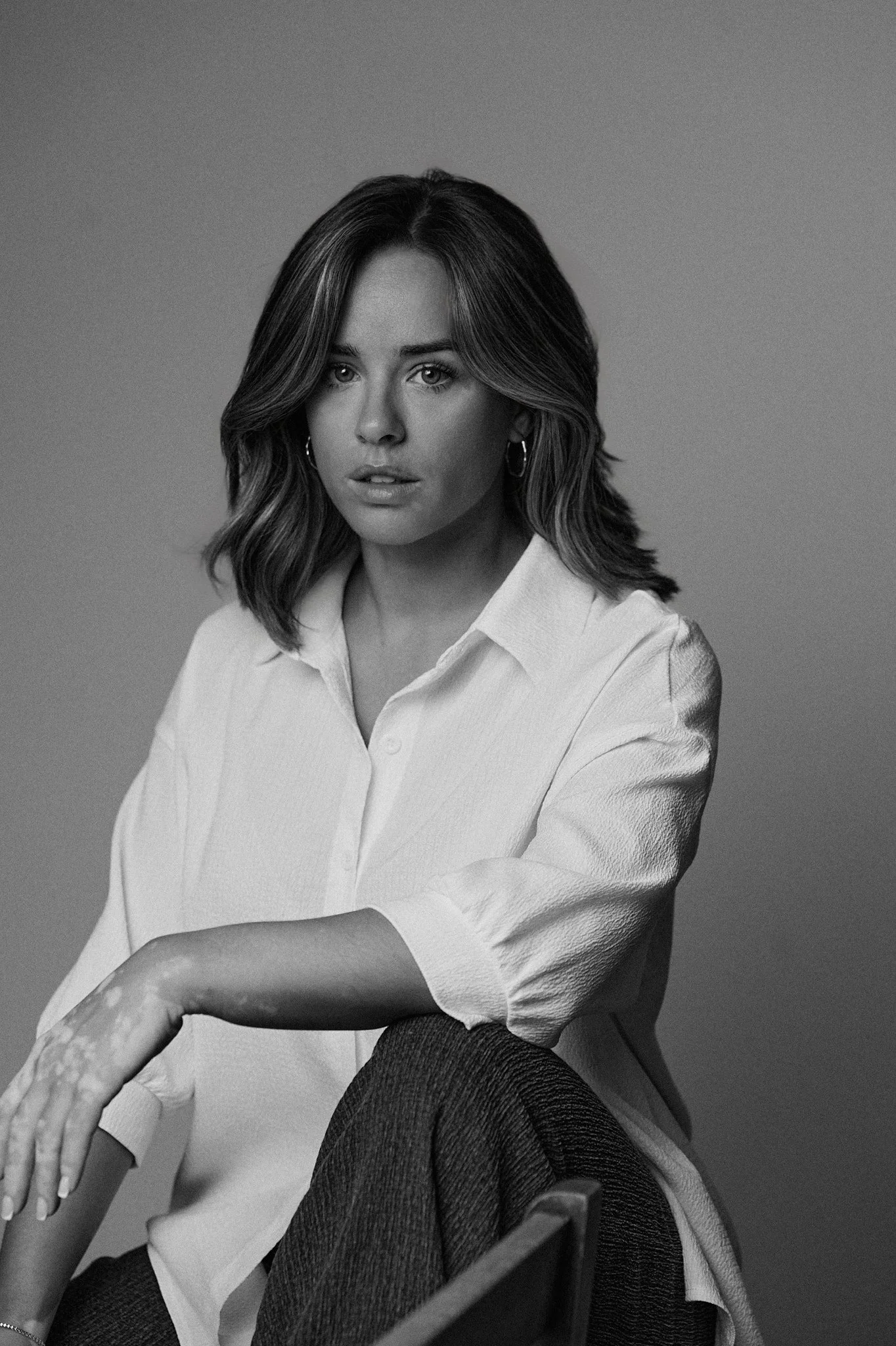 Georgia May Foote seated portrait with neutral studio background