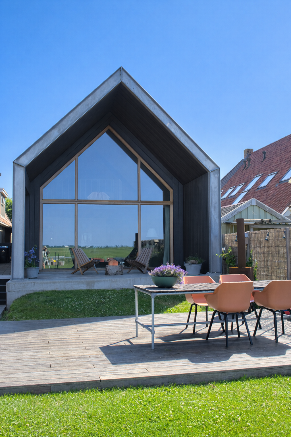 Moderne uitbouw van een woning ontworpen door Atelier Koree. De houten gevel, royale glaspartij en eenvoudige kapvorm zorgen voor een lichte en tijdloze leefruimte met zicht op het landschap.