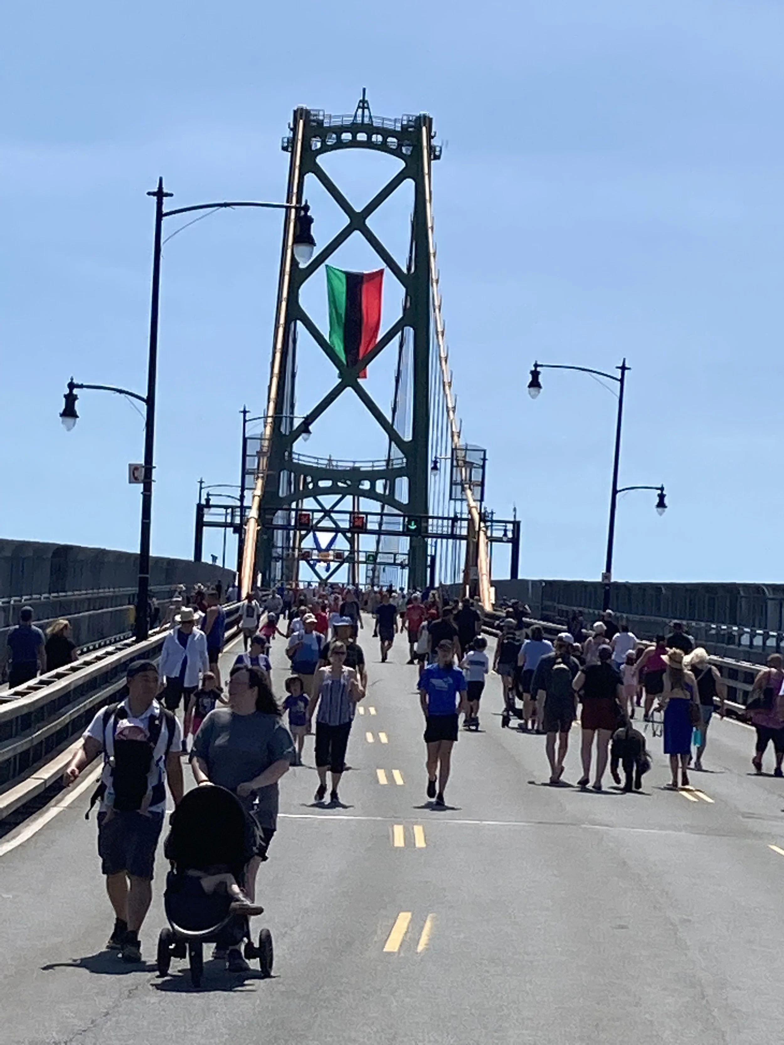 The flag marking ten end of slavery in the Commonwealth danced in the wind as families took in Bridgewalk