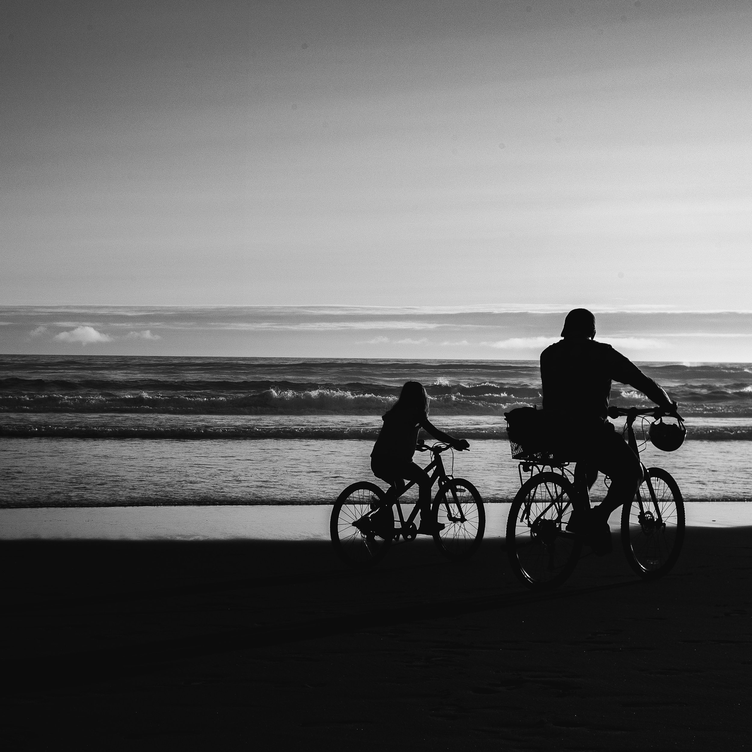 A father and daughter pass by on their bikes one July in 2022