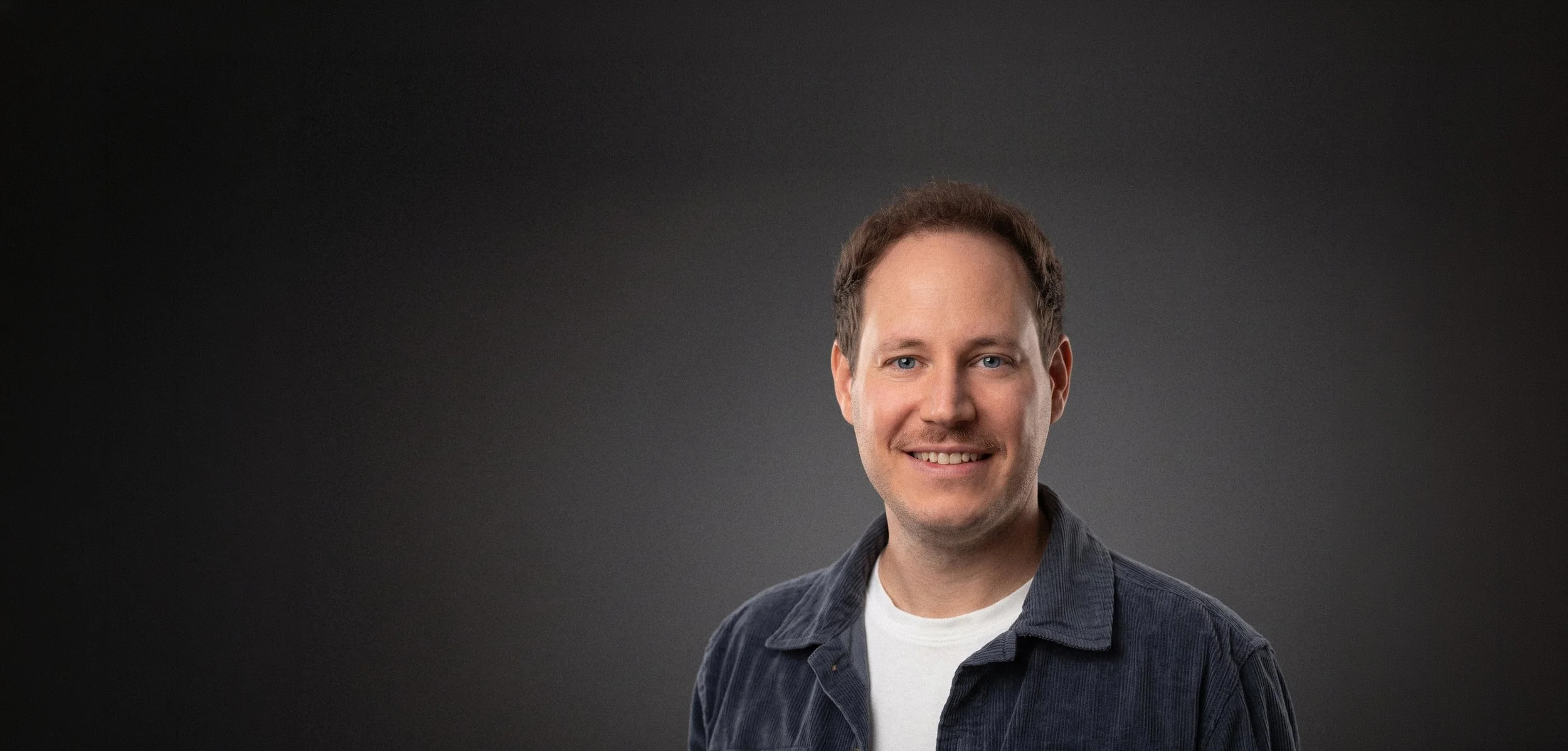 Portrait Bild von Dominic Baumann in einem Studio