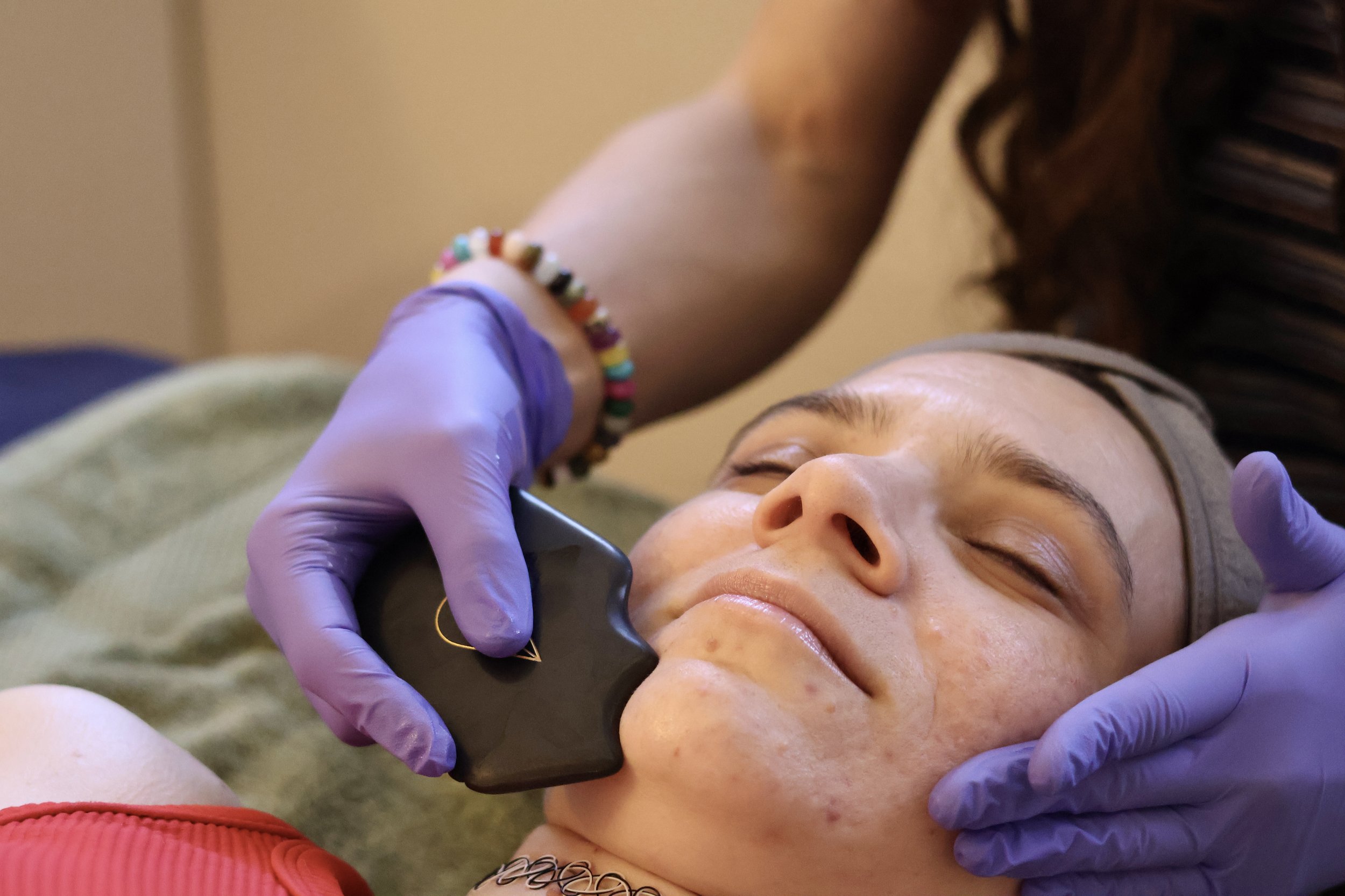 A woman receiving a gua Sha facial