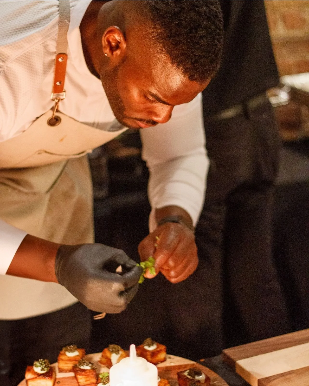 Chef Brandon Rogers, LLC. | Chicago | Traveling Private Chef Garnishing Small Appetizer Dish With Herbs In A Restaurant Kitchen