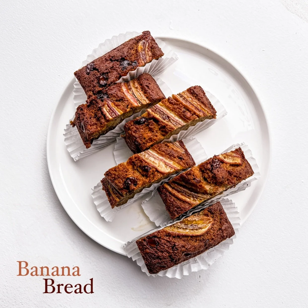 Banana bread, but make it extra. 🍌✨ Rich, moist, and loaded with chocolate chunks&mdash;perfect with your coffee. Grab a slice (or two) today! ☕💛 #BananaBread #CafeVibes #bakedwithlove 
#kanomcafe #baltimorefood