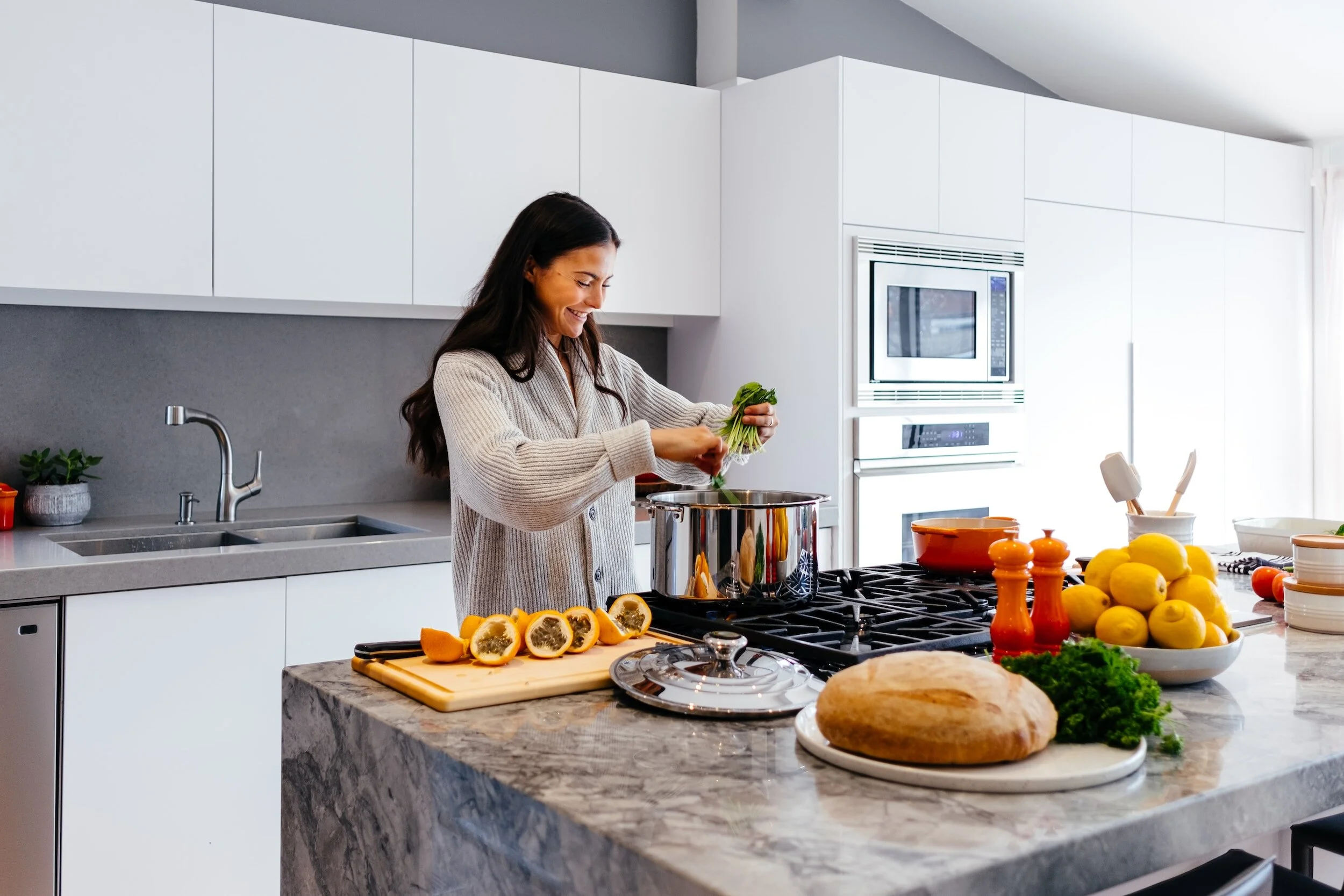 Woman cooking on stove with Grey Granite countertops - Innovative Countertop Solutions