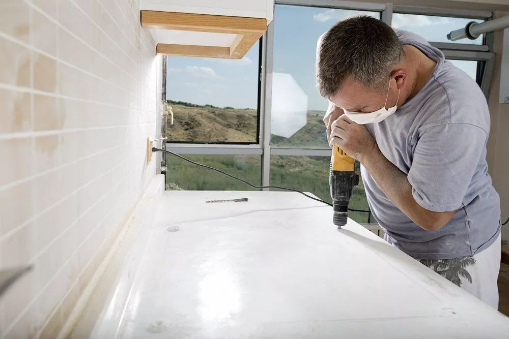 Specialist working on drilling a countertop - Innovative Countertop Solutions