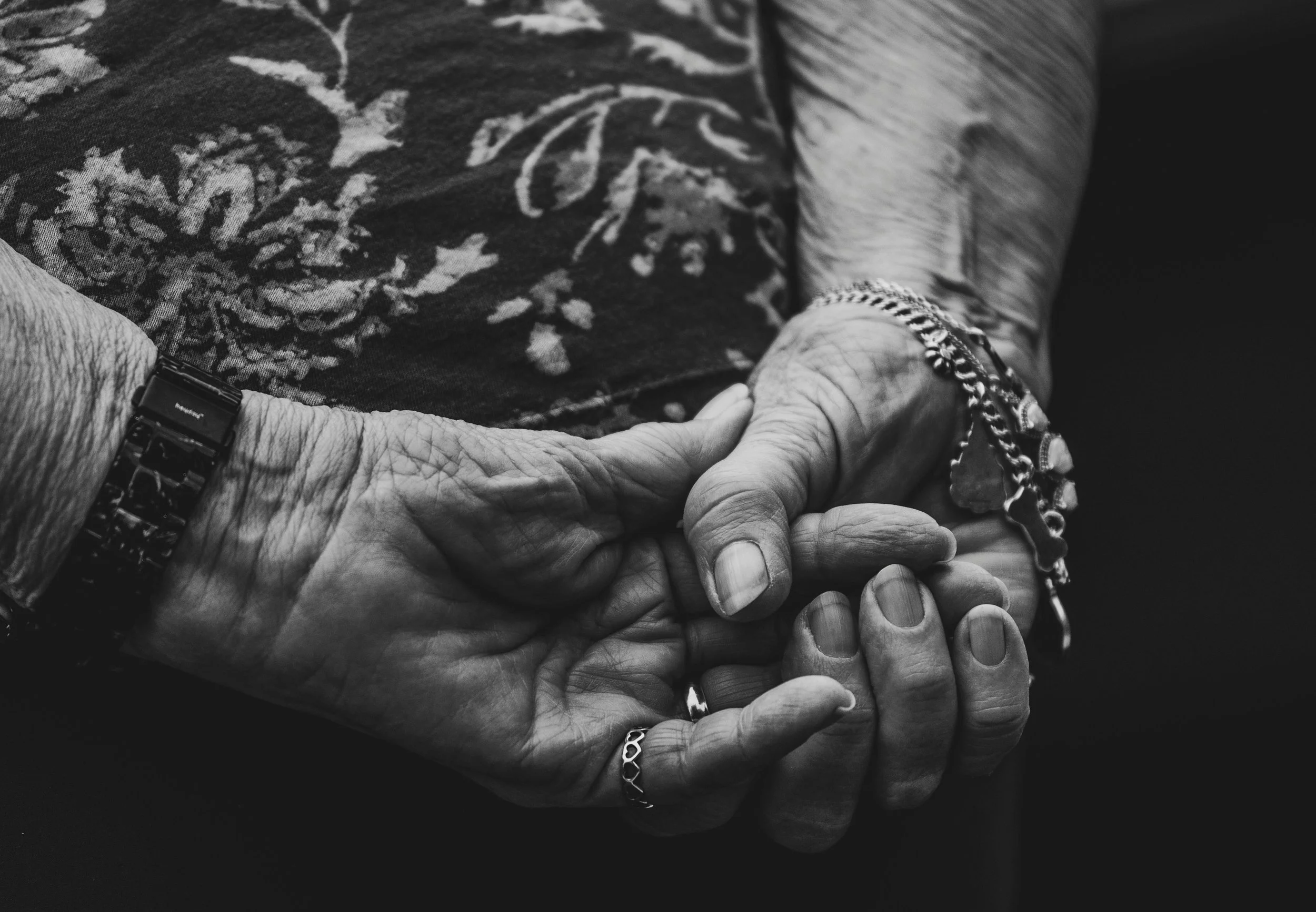 two elderly people holding hands