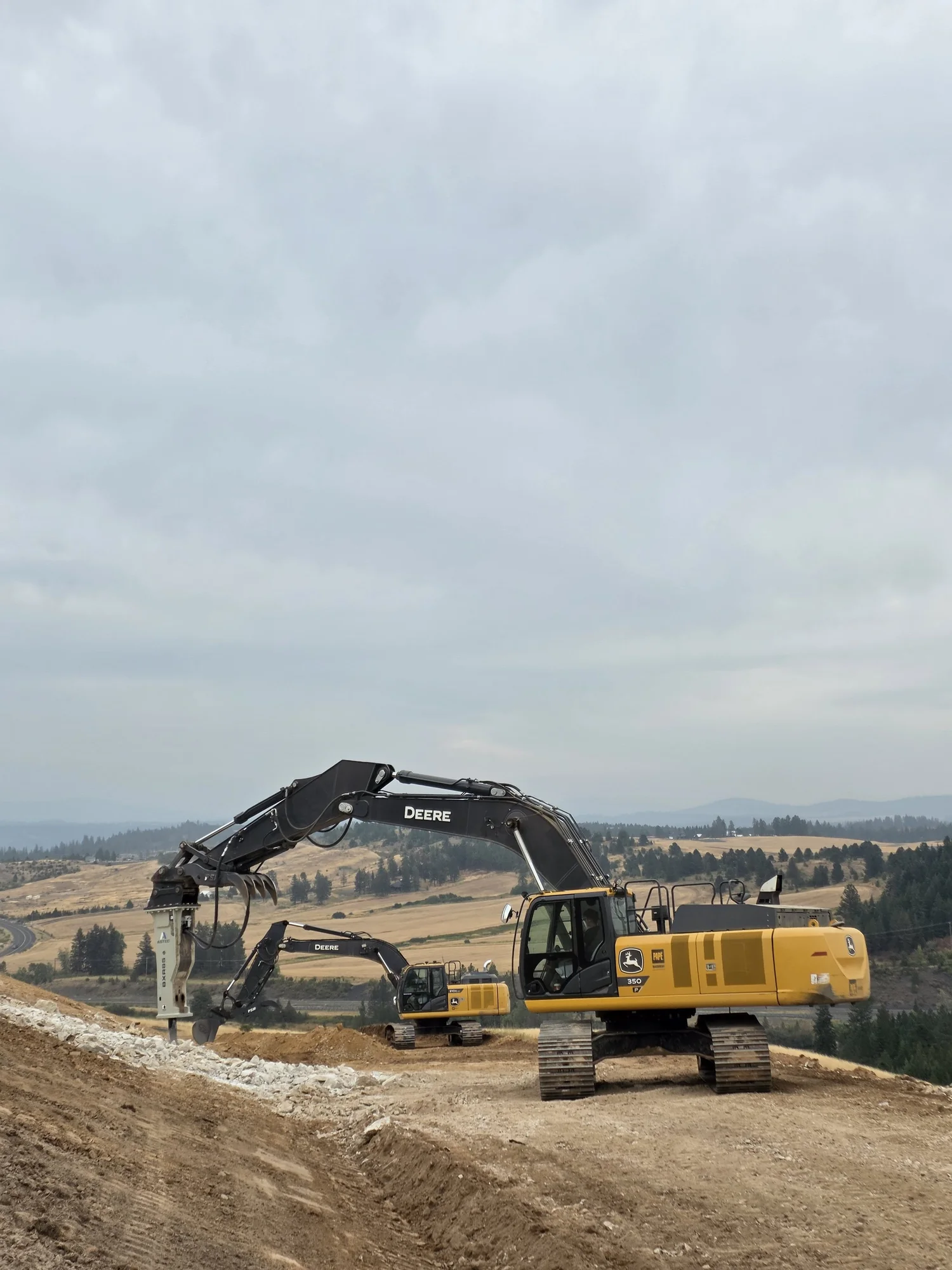 Full view of EXCO excavators and attachments on an earthmoving jobsite.