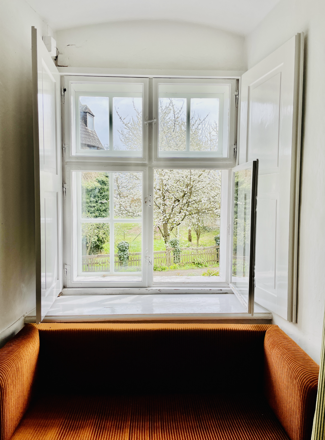 Open doorway and window looking into a green garden.
