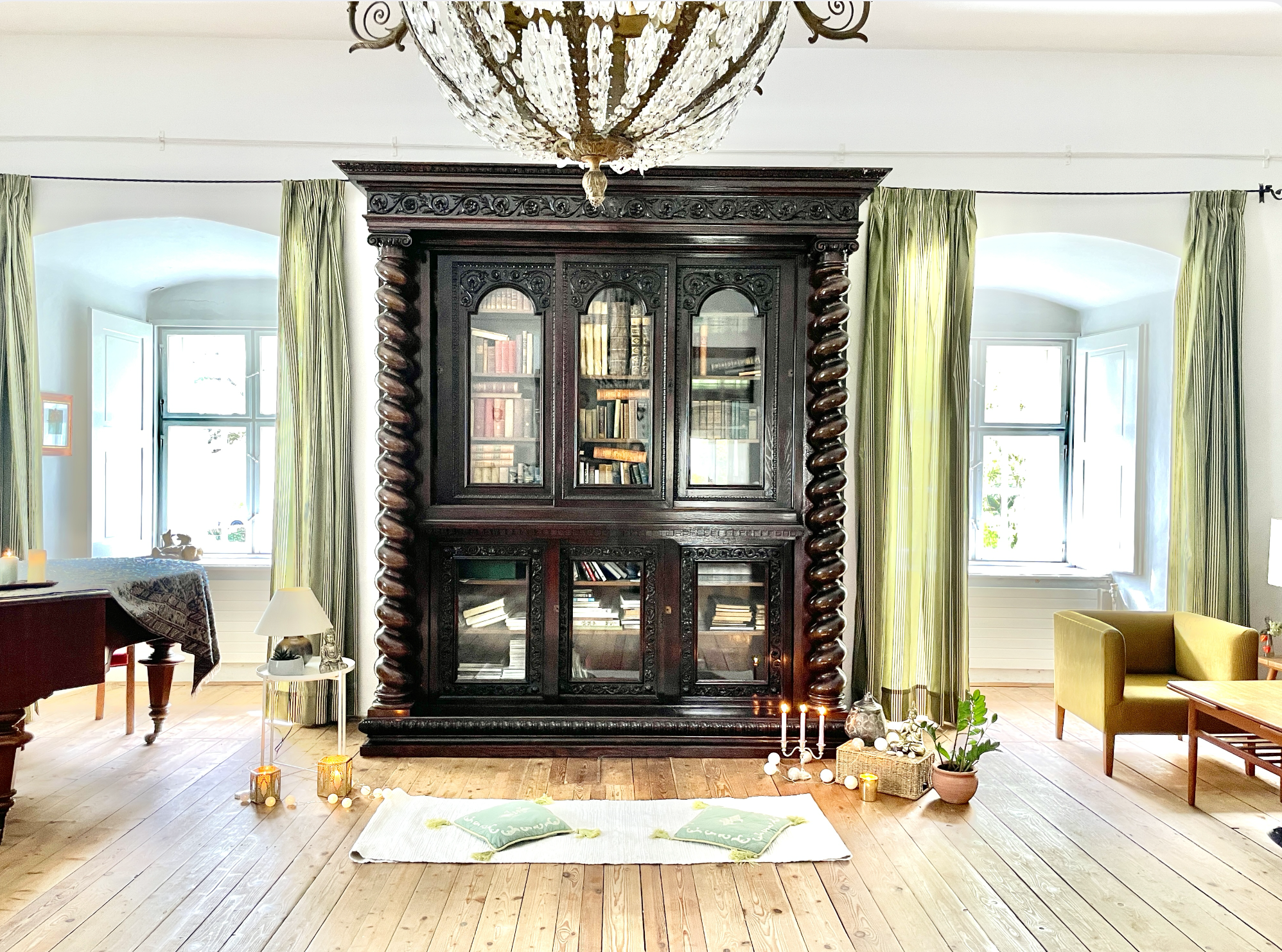 Light-filled sanctuary space with candles and antique furnishings.
