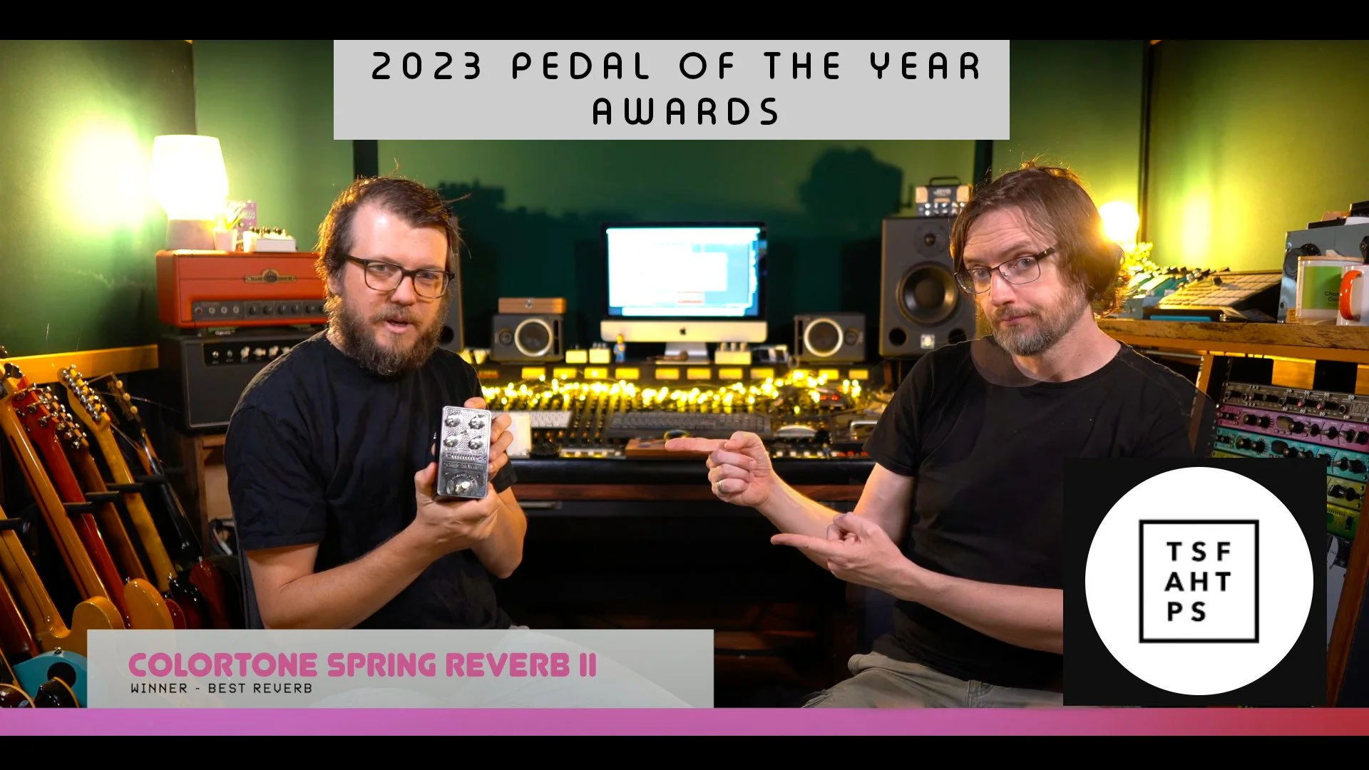 Two men in a recording studio holding an effects pedal and pointing at it, with a computer monitor and mixing equipment in the background, celebrating the 2023 Pedal of the Year award for the ColorTone Spring Reverb II.