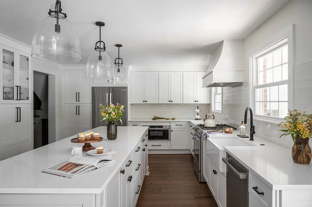 White kitchen with dark wood flooring.