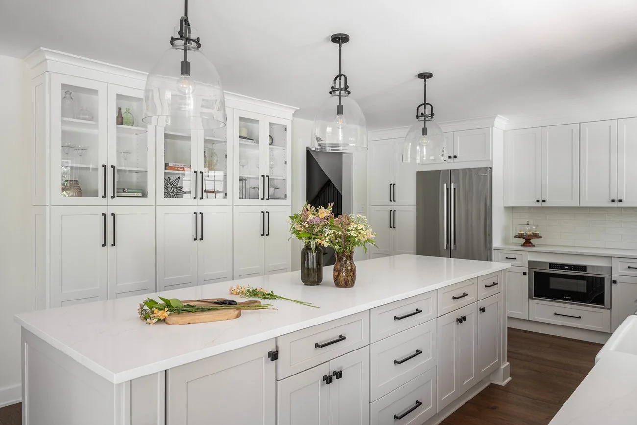 Large island in a light warm gray with three pendants above.