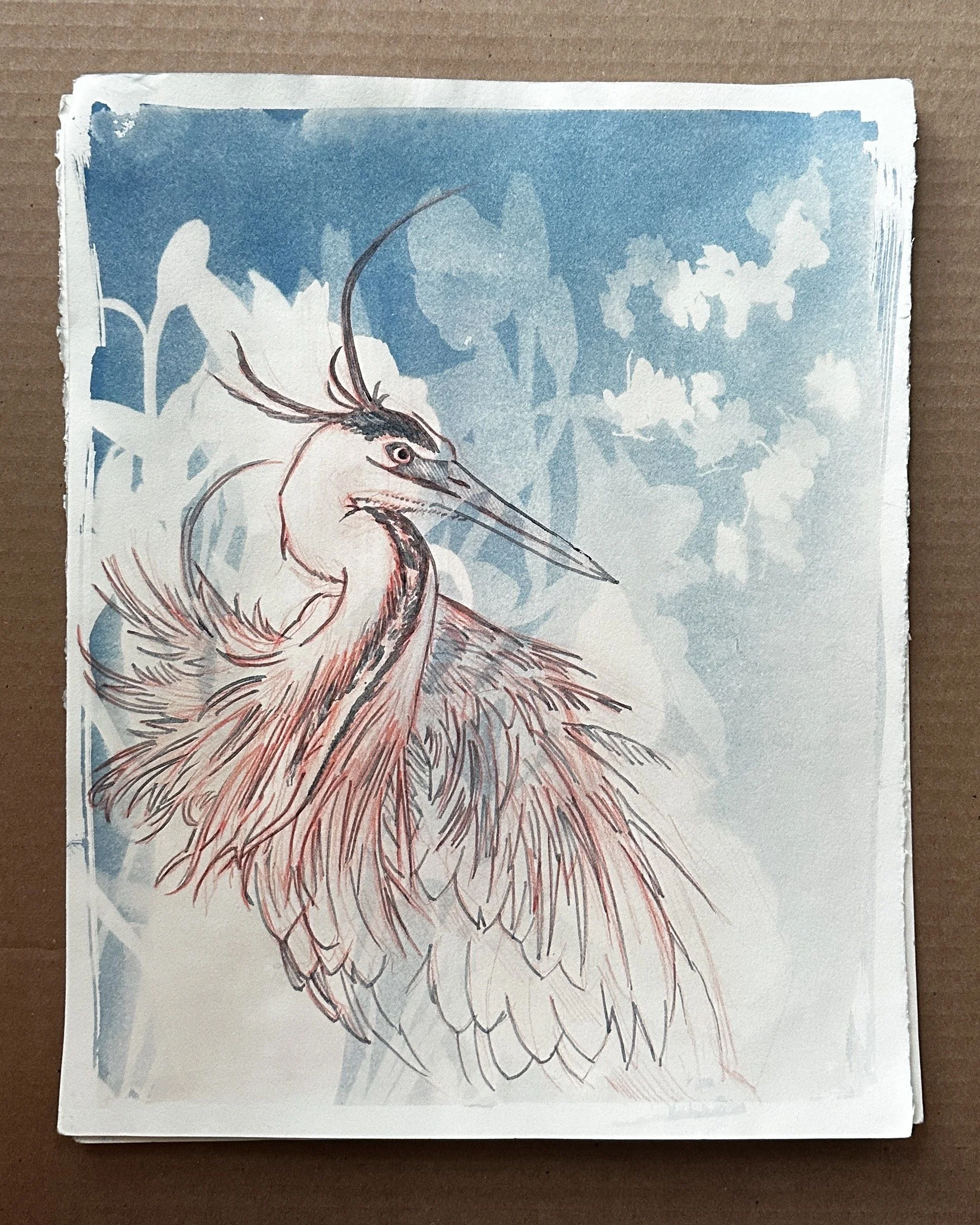 A printed illustration of a heron with a long beak and prominent neck in front of a blue sky background with clouds, on a piece of paper with uneven edges.