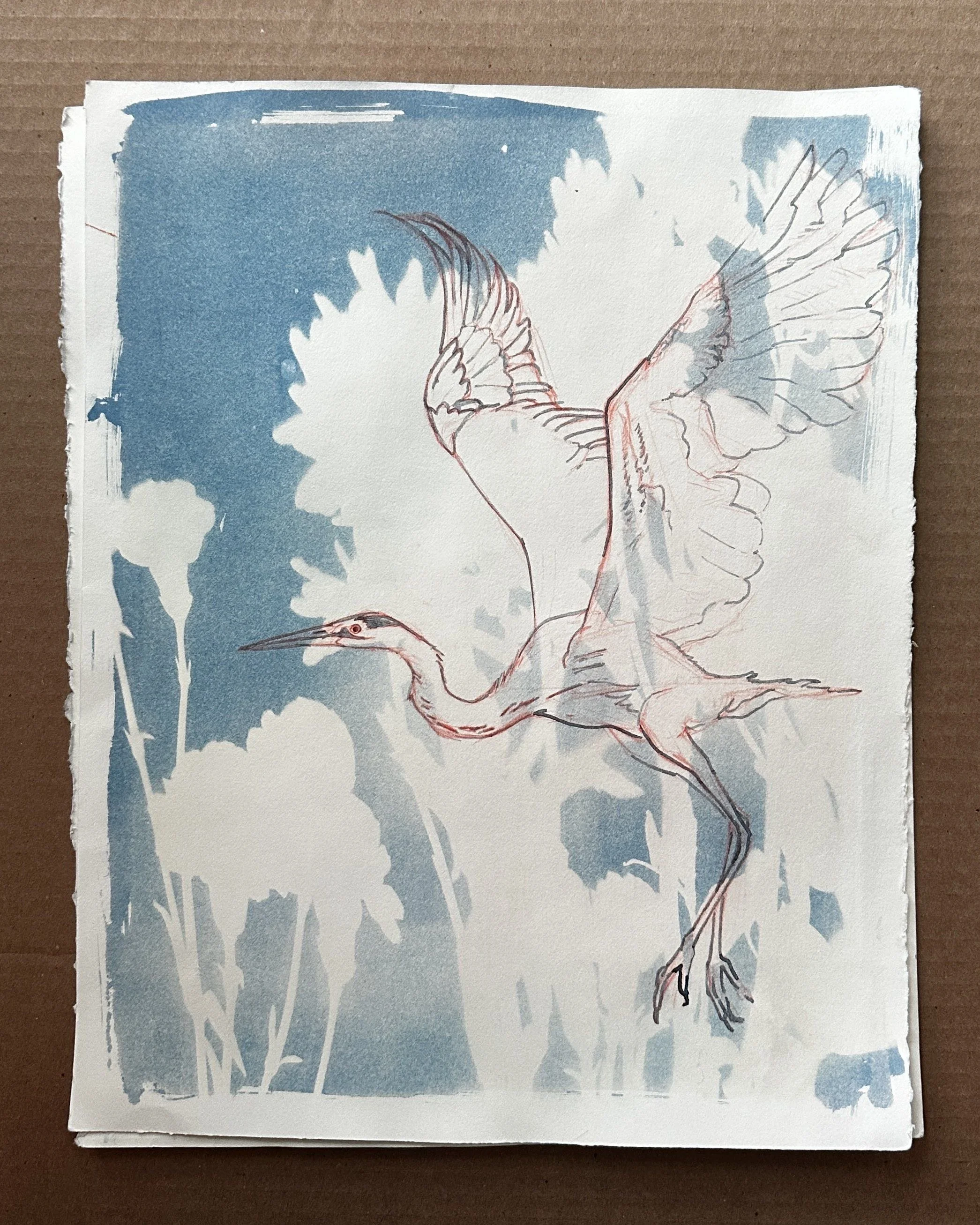 A stack of paper sheets with a sketch of a bird, possibly a heron, on the top sheet. The background has blue paint strokes.