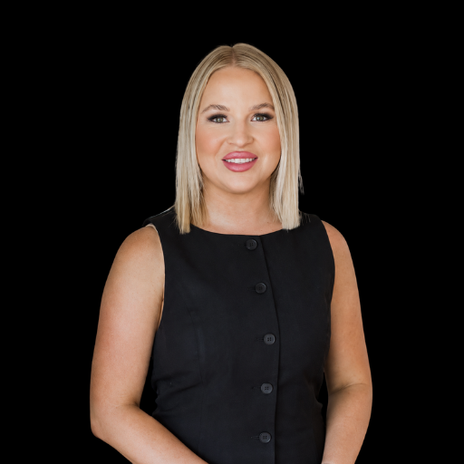 A woman with shoulder-length blonde hair, smiling, and a black hoodie with the AllClear Health logo, standing against a black background.