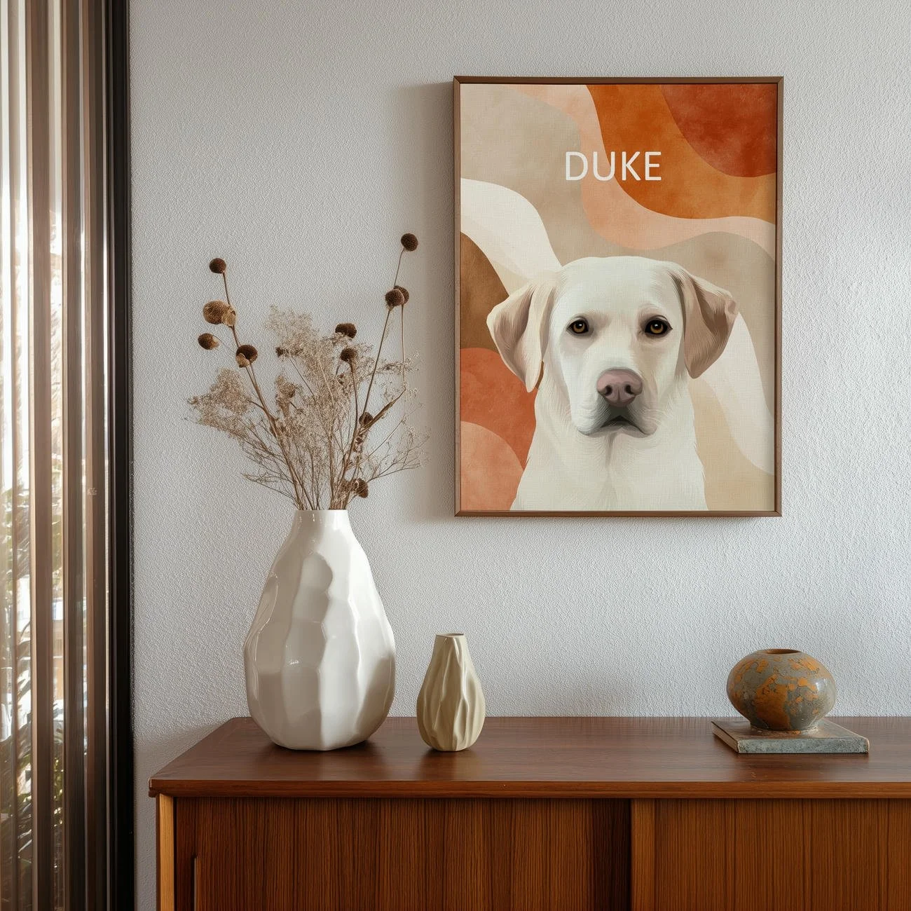A custom dog portrait of Duke illustrated against a mid-century abstract background in warm earth tones, framed in walnut and styled as modern wall art above a wooden console.