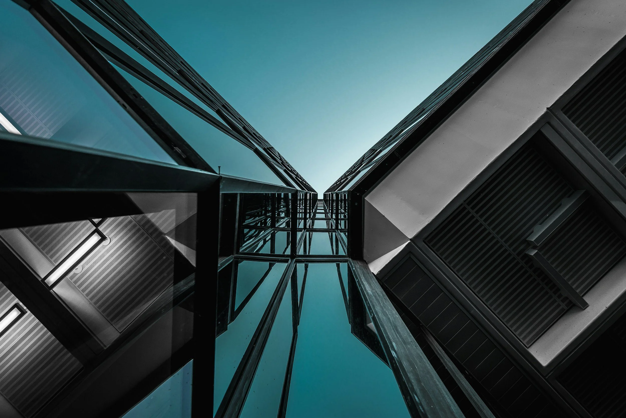 Low-angle view of a modern glass building against a clear sky.