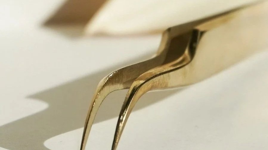 Close-up of a silver fork casting a shadow on a white surface.