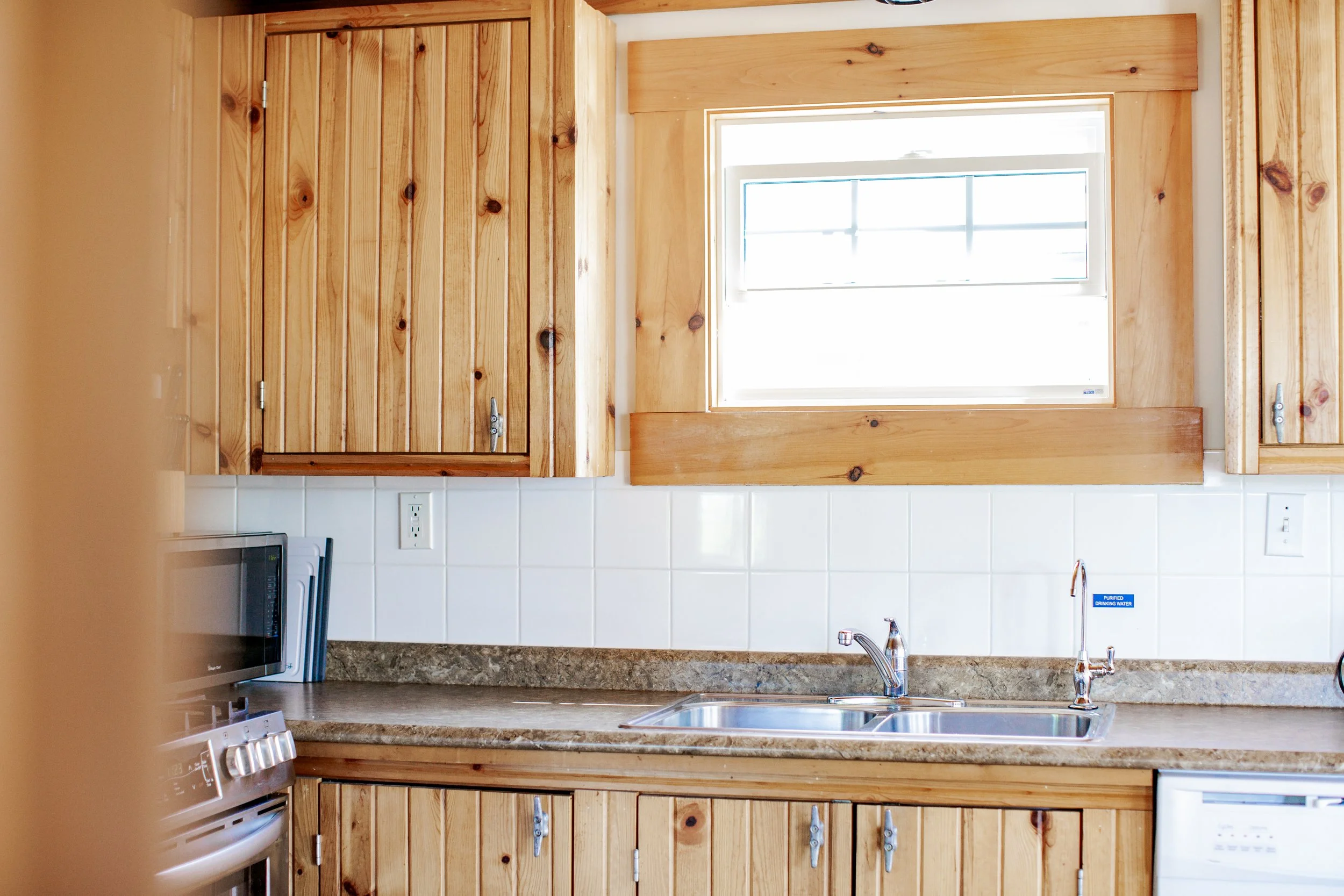 Kitchen with wooden cabinets, a window above the sink, and a granite countertop.